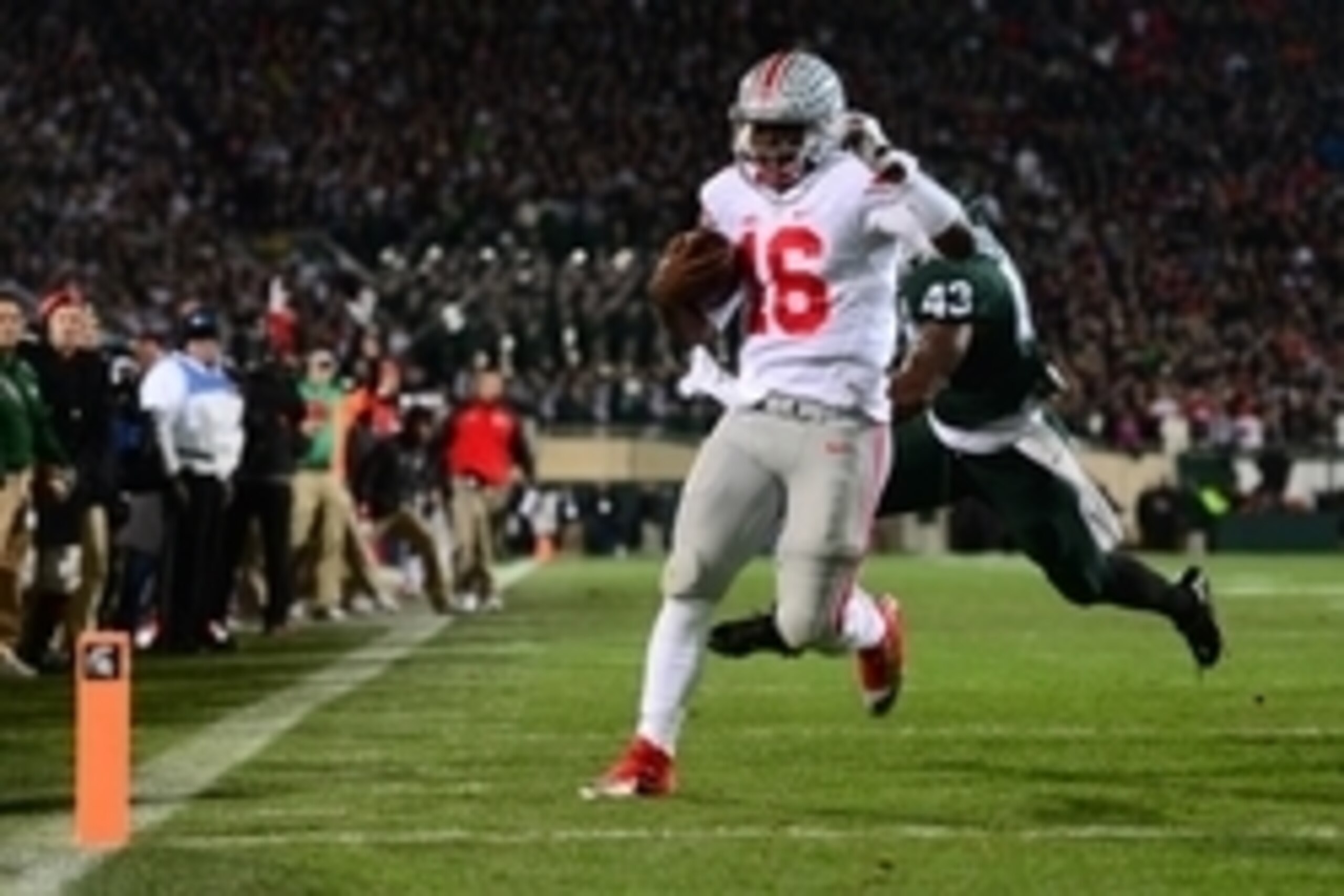Nov 8, 2014; East Lansing, MI, USA; Ohio State Buckeyes quarterback J.T. Barrett (16) runs the ball into the end zone for a touchdown during the first quarter against the Michigan State Spartans at Spartan Stadium. Mandatory Credit: Andrew Weber-USA TODAY