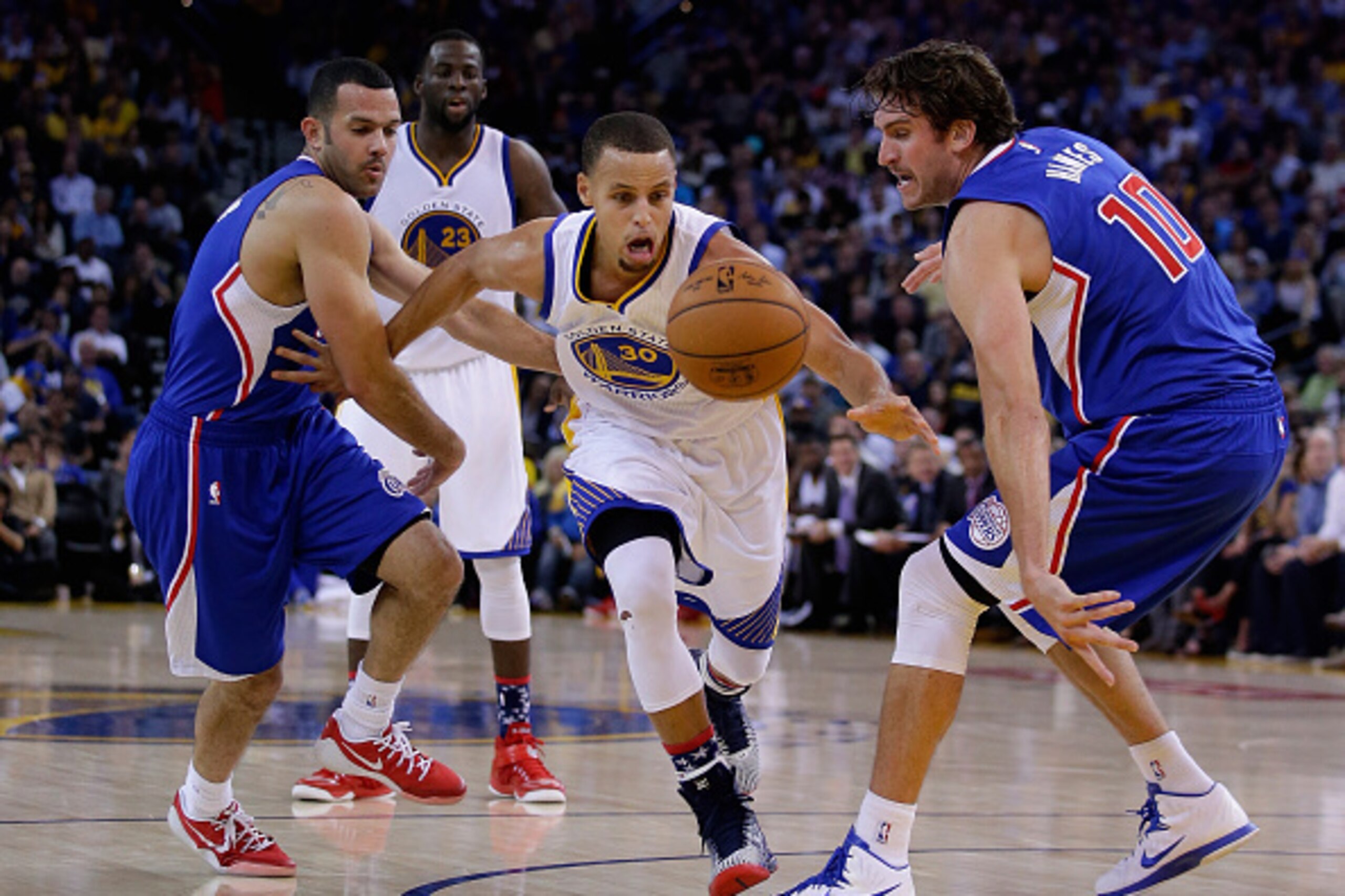 OAKLAND, CA - NOVEMBER 05:  Stephen Curry #30 of the Golden State Warriors dribbles through Jordan Farmar #1 and Spencer Hawes #10 of the Los Angeles Clippers at ORACLE Arena on November 5, 2014 in Oakland, California. NOTE TO USER: User expressly acknowl