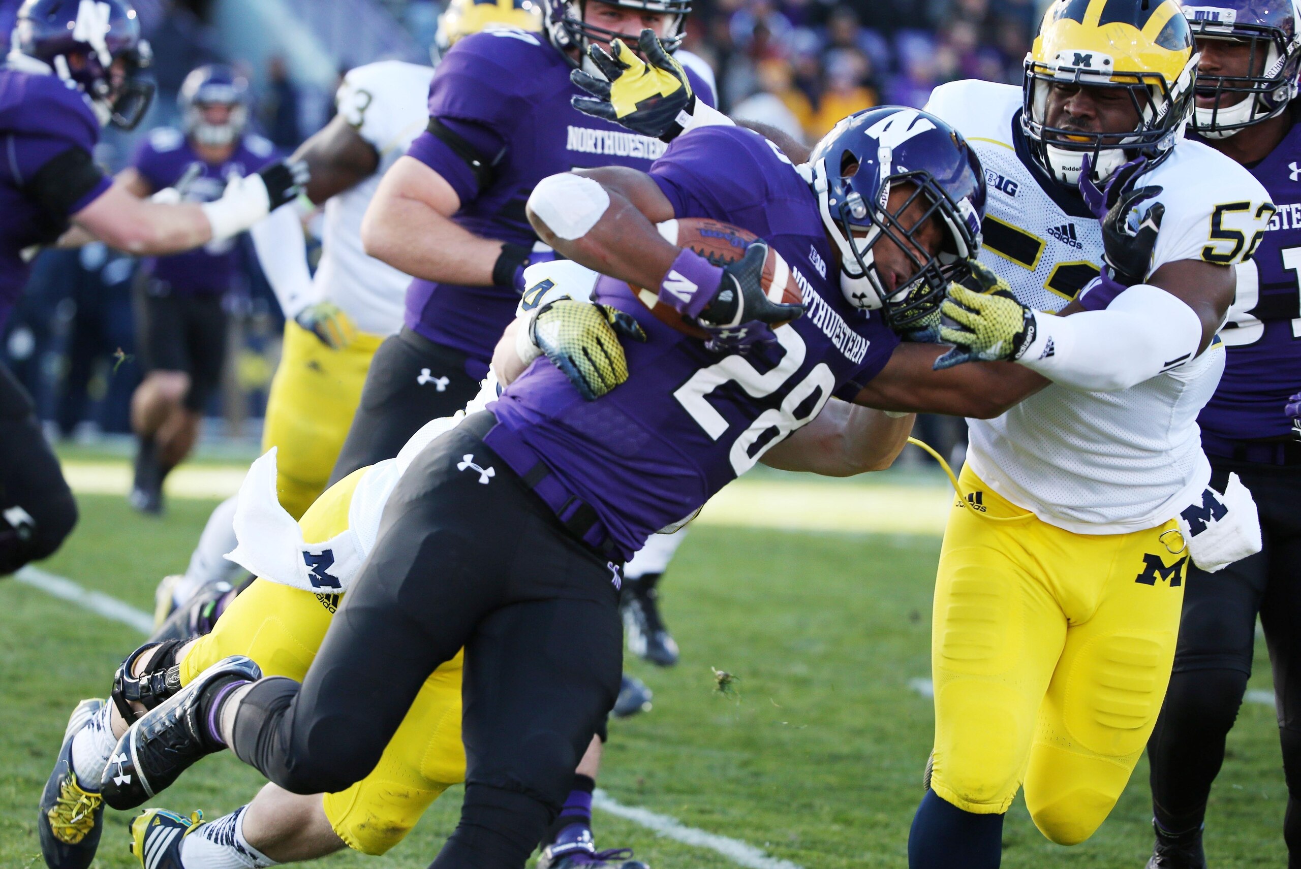 Nov 8, 2014; Evanston, IL, USA; Northwestern Wildcats running back Justin Jackson (28) is tackled by Michigan Wolverines linebacker Jake Ryan (47) and Michigan Wolverines linebacker Royce Jenkins-Stone (52) in the first half at Ryan Field. Mandatory Credi