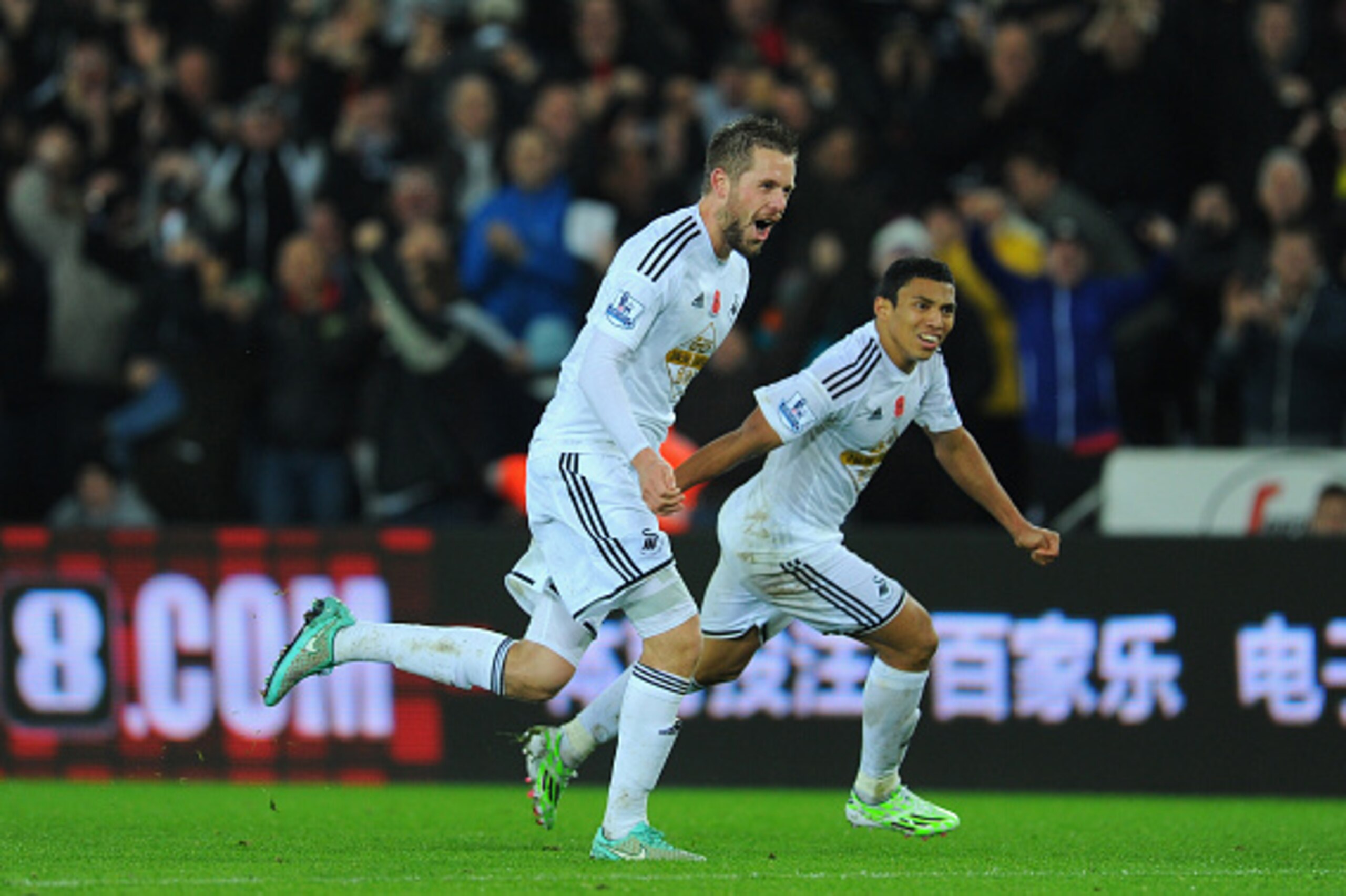 SWANSEA, WALES - NOVEMBER 09:  Swansea players Gylfi Sigurdsson (l) and Jefferson Montero celebrate the first Swansea goal during the Barclays Premier League match between Swansea City and Arsenal at Liberty Stadium on November 9, 2014 in Swansea, Wales. 