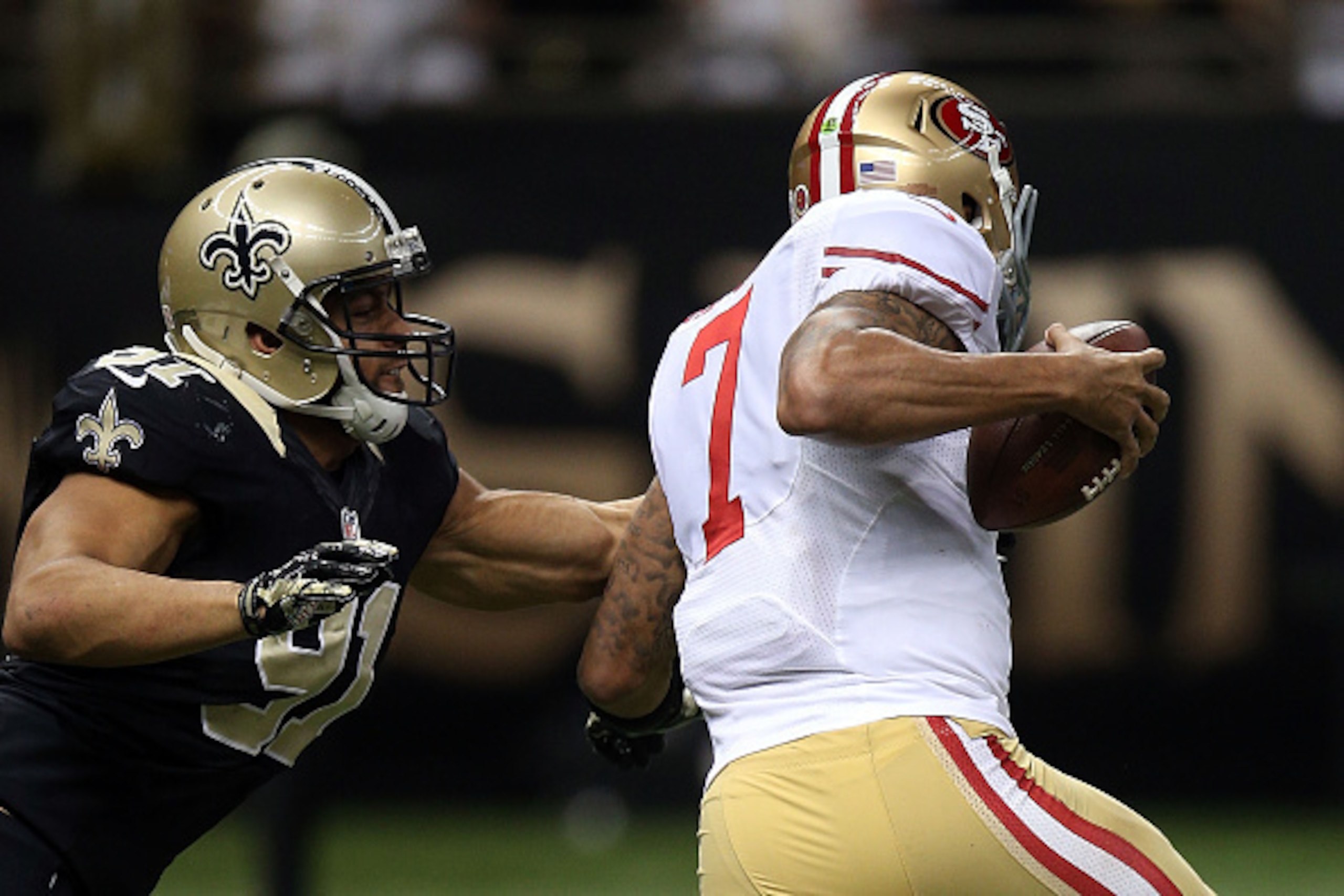 NEW ORLEANS, LA - NOVEMBER 09:  Kasim Edebali #91 of the New Orleans Saints pressures Colin Kaepernick #7 of the San Francisco 49ers during the third quarter of a game at the Mercedes-Benz Superdome on November 9, 2014 in New Orleans, Louisiana.  (Photo b