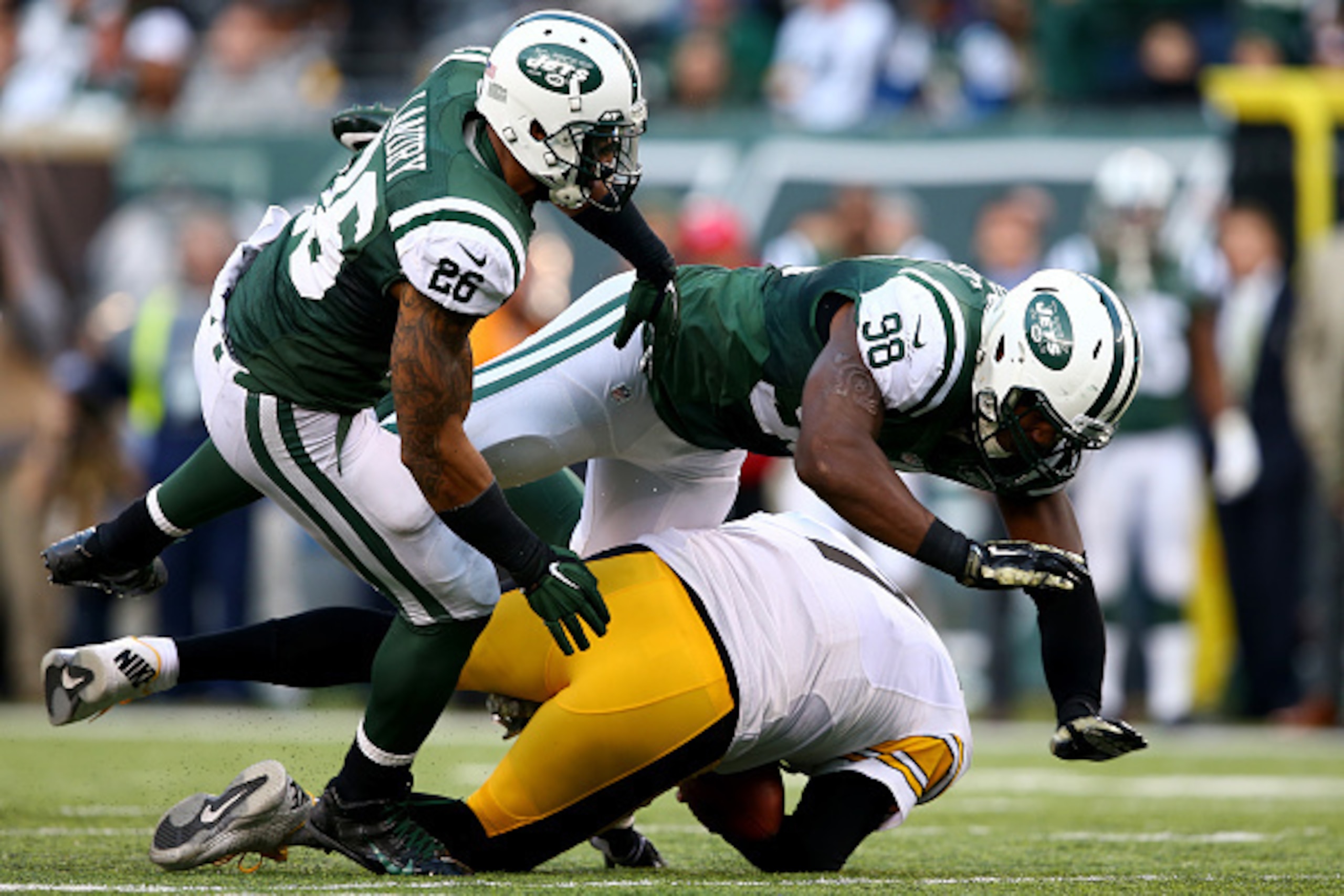 EAST RUTHERFORD, NJ - NOVEMBER 09:  Outside linebacker Quinton Coples #98 and strong safety Dawan Landry #26 of the New York Jets go for a loose ball against quarterback Ben Roethlisberger #7 of the Pittsburgh Steelers during a game at MetLife Stadium on 
