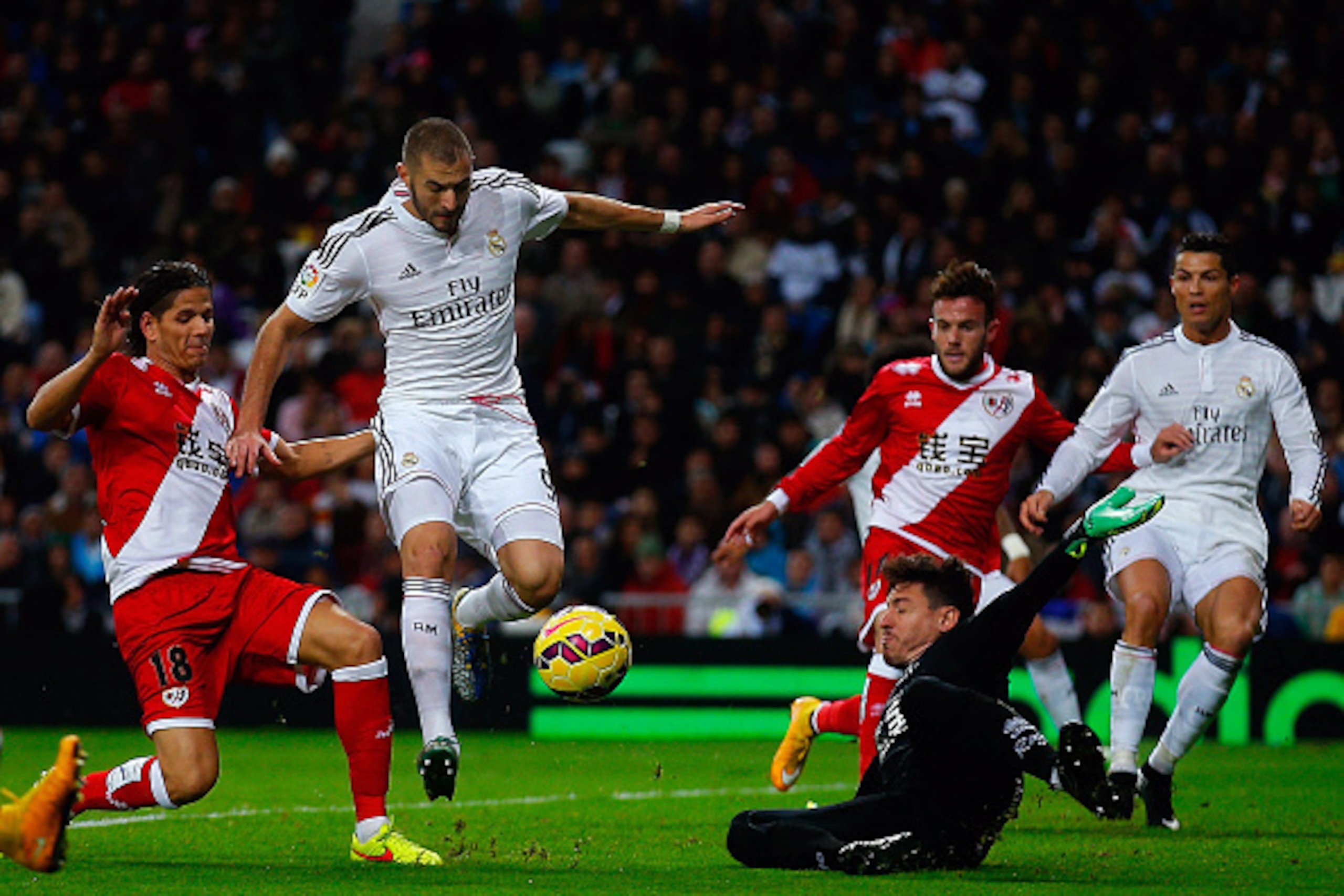 MADRID, SPAIN - NOVEMBER 08: Karim Benzema (2ndL) of Real Madrid CF competes for the ball with Ze Castro (L) of Rayo Vallecano de Madrid and his teammate goalkeeper Cristian Dario Alvarez Azad (R) during the La Liga match between Real Madrid CF and Rayo V