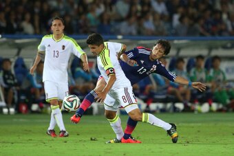YOKOHAMA, JAPAN - SEPTEMBER 09:  Tomas Rincon (L) of Venezuela and Hajime Hosogai (R) of Japan compete for the ball during the KIRIN CHALLENGE CUP 2014 international friendly match between Japan and Venezuela at the International Stadium Yokohama on Septe