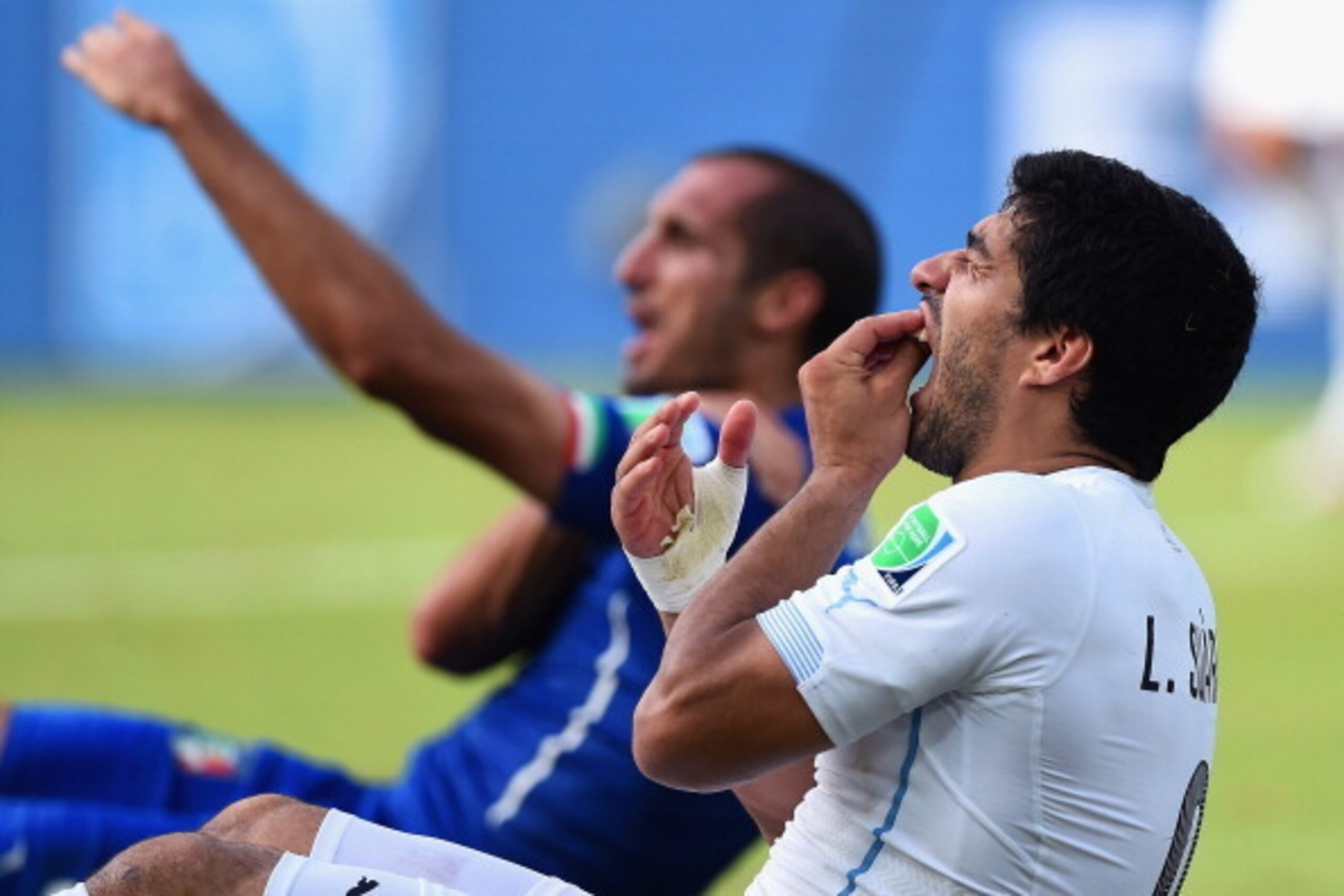 NATAL, BRAZIL - JUNE 24:  Luis Suarez of Uruguay and Giorgio Chiellini of Italy react after a clash during the 2014 FIFA World Cup Brazil Group D match between Italy and Uruguay at Estadio das Dunas on June 24, 2014 in Natal, Brazil.  (Photo by Matthias H