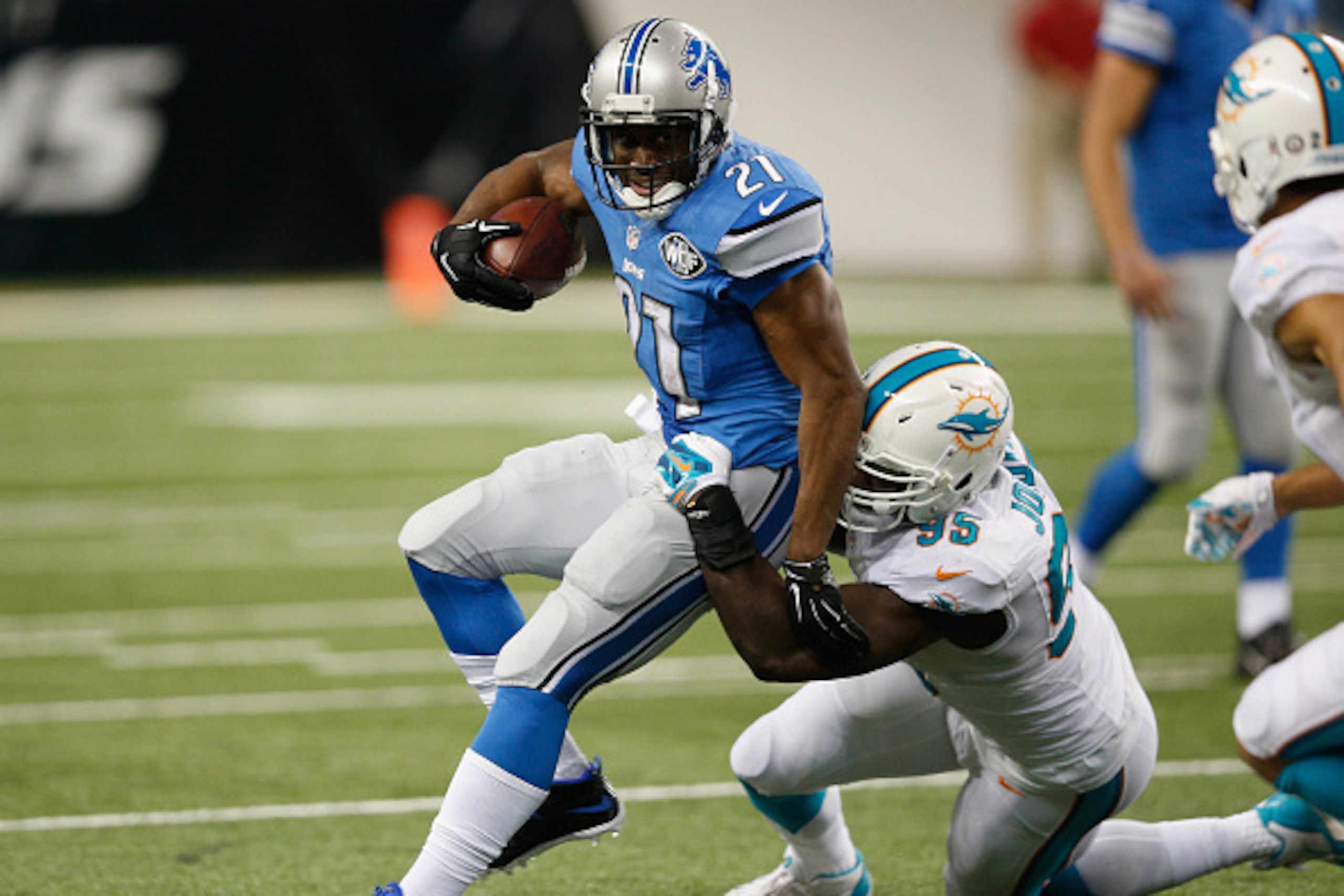 DETROIT, MI - NOVEMBER 09: Reggie Bush #21 of the Detroit Lions tries to avoid the tackle by Dion Jordan #95 of the Miami Dolphins in the third quarter at Ford Field on November 09, 2014 in Detroit, Michigan. (Photo by Joe Robbins/Getty Images)