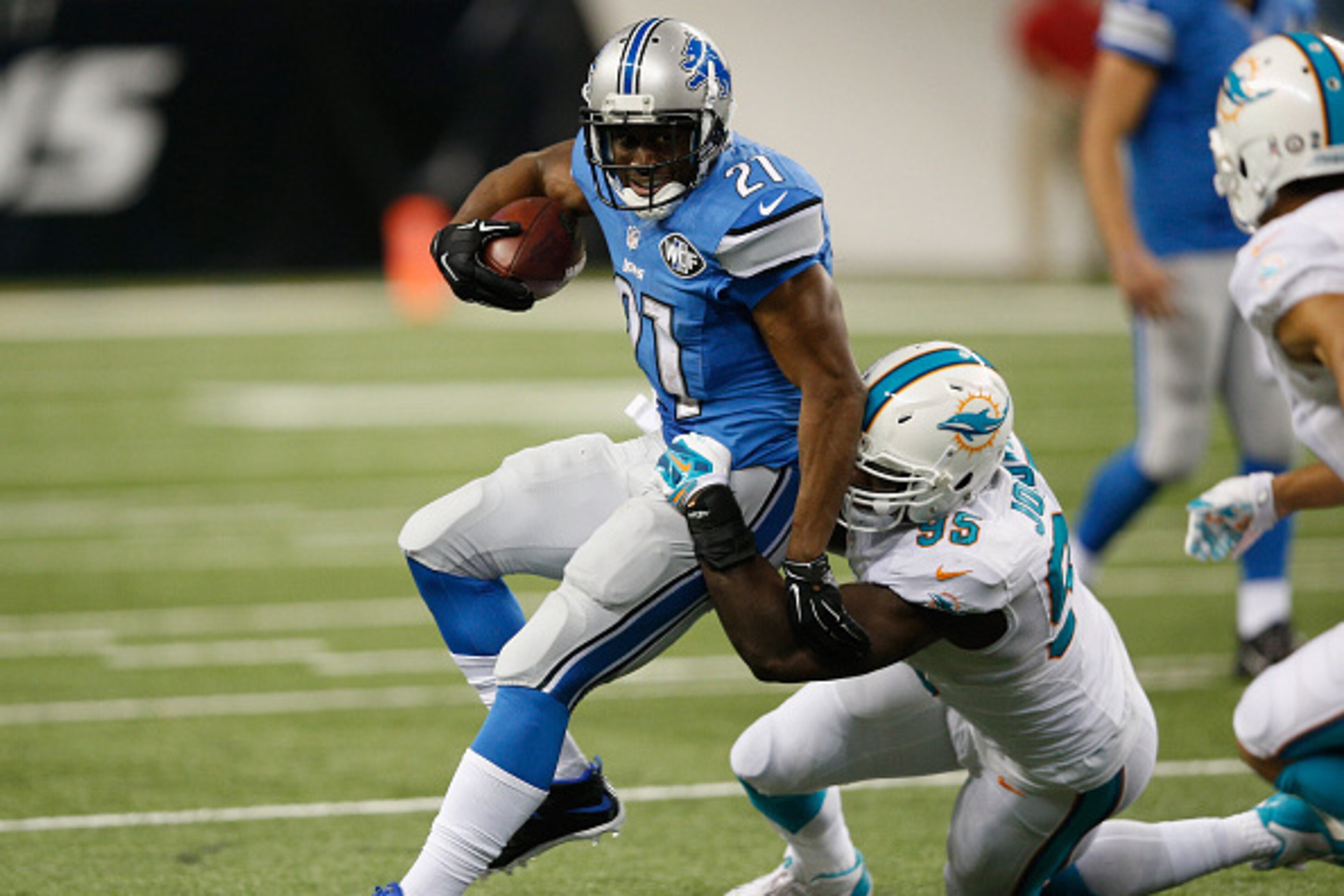 DETROIT, MI - NOVEMBER 09: Reggie Bush #21 of the Detroit Lions tries to avoid the tackle by Dion Jordan #95 of the Miami Dolphins in the third quarter at Ford Field on November 09, 2014 in Detroit, Michigan. (Photo by Joe Robbins/Getty Images)