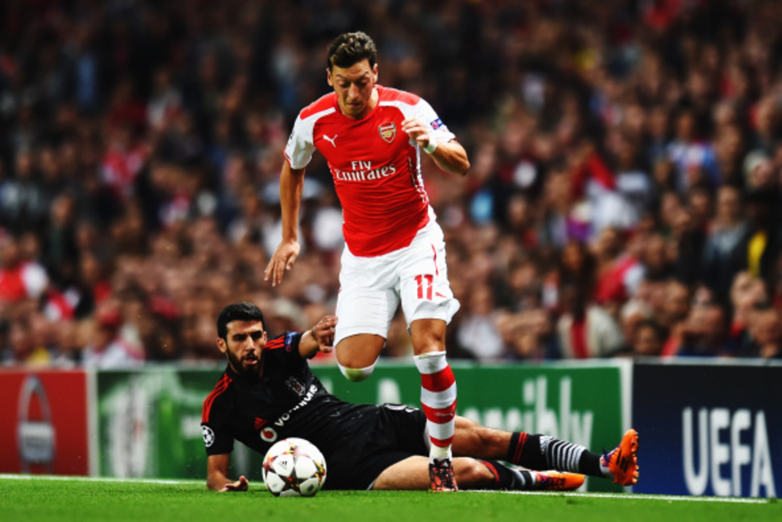 LONDON, ENGLAND - AUGUST 27:  Mesut Oezil of Arsenal skips the tackle of Ismail Koybasl of Besiktas during the UEFA Champions League Qualifier 2nd leg match between Arsenal and Besiktas at the Emirates Stadium on August 27, 2014 in London, United Kingdom.
