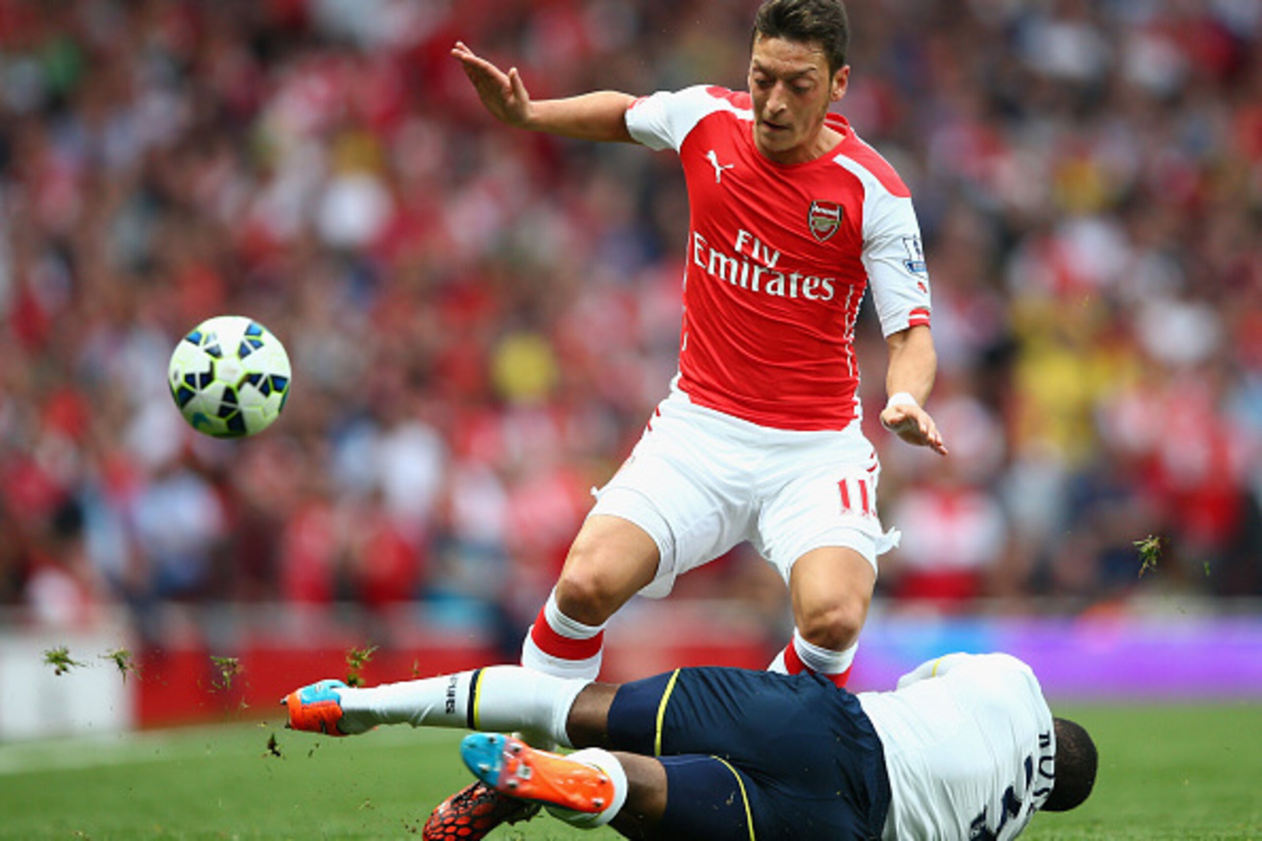 LONDON, ENGLAND - SEPTEMBER 27:  Mesut Oezil of Arsenal in action against Danny Rose of Spurs during the Barclays Premier League match between Arsenal and Tottenham Hotspur at Emirates Stadium on September 27, 2014 in London, England.  (Photo by Paul Gilh