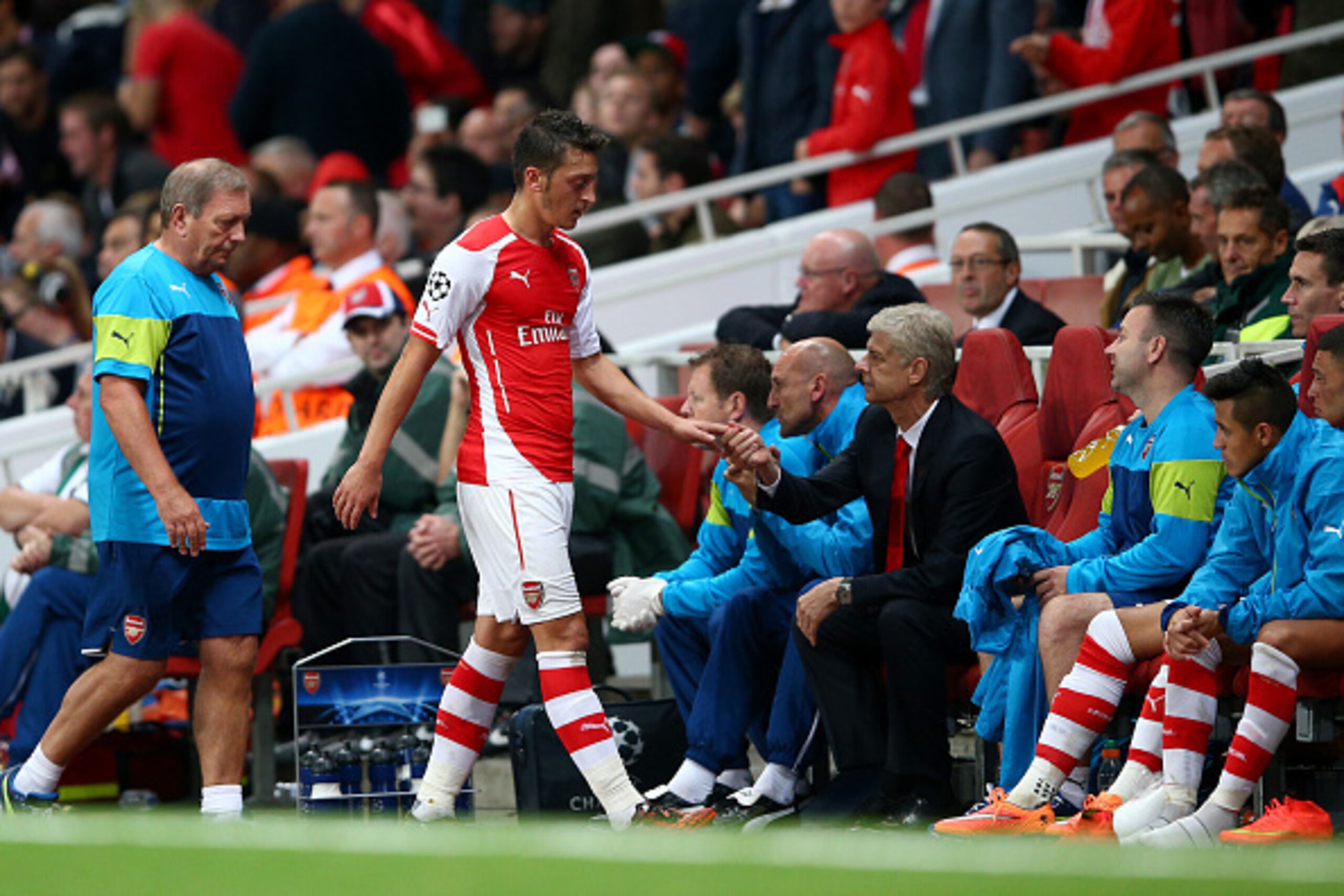 LONDON, ENGLAND - OCTOBER 01:  Mesut Oezil of Arsenal shakes hands with Arsene Wenger, manager of Arsenal after being substituted during the UEFA Champions League group D match between Arsenal FC and Galatasaray AS at Emirates Stadium on October 1, 2014 i