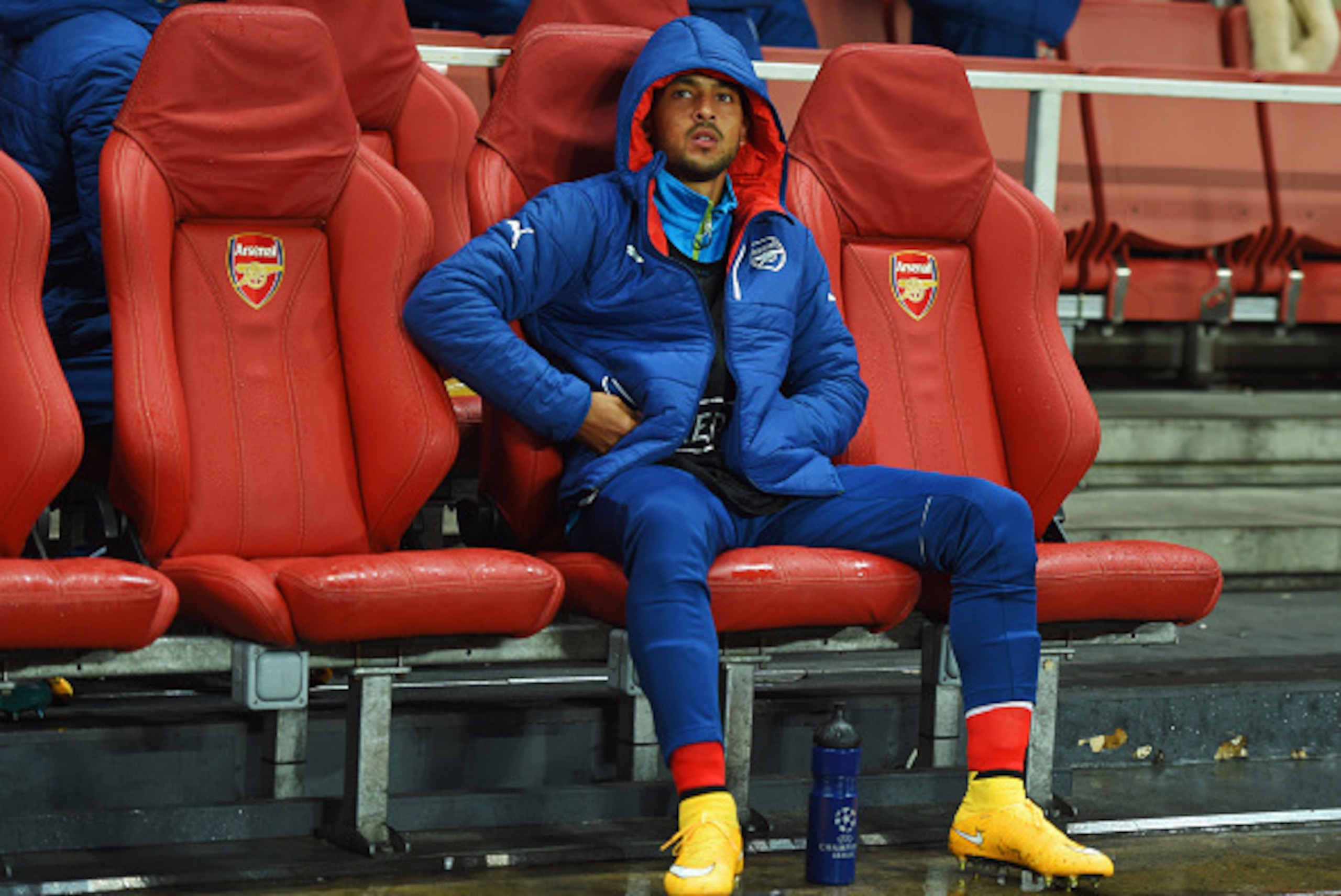 LONDON, ENGLAND - NOVEMBER 04:  Substitute Theo Walcott of Arsenal looks thoughtful as he sits on the bench prior to the UEFA Champions League Group D match between Arsenal FC and RSC Anderlecht at Emirates Stadium on November 4, 2014 in London, United Ki