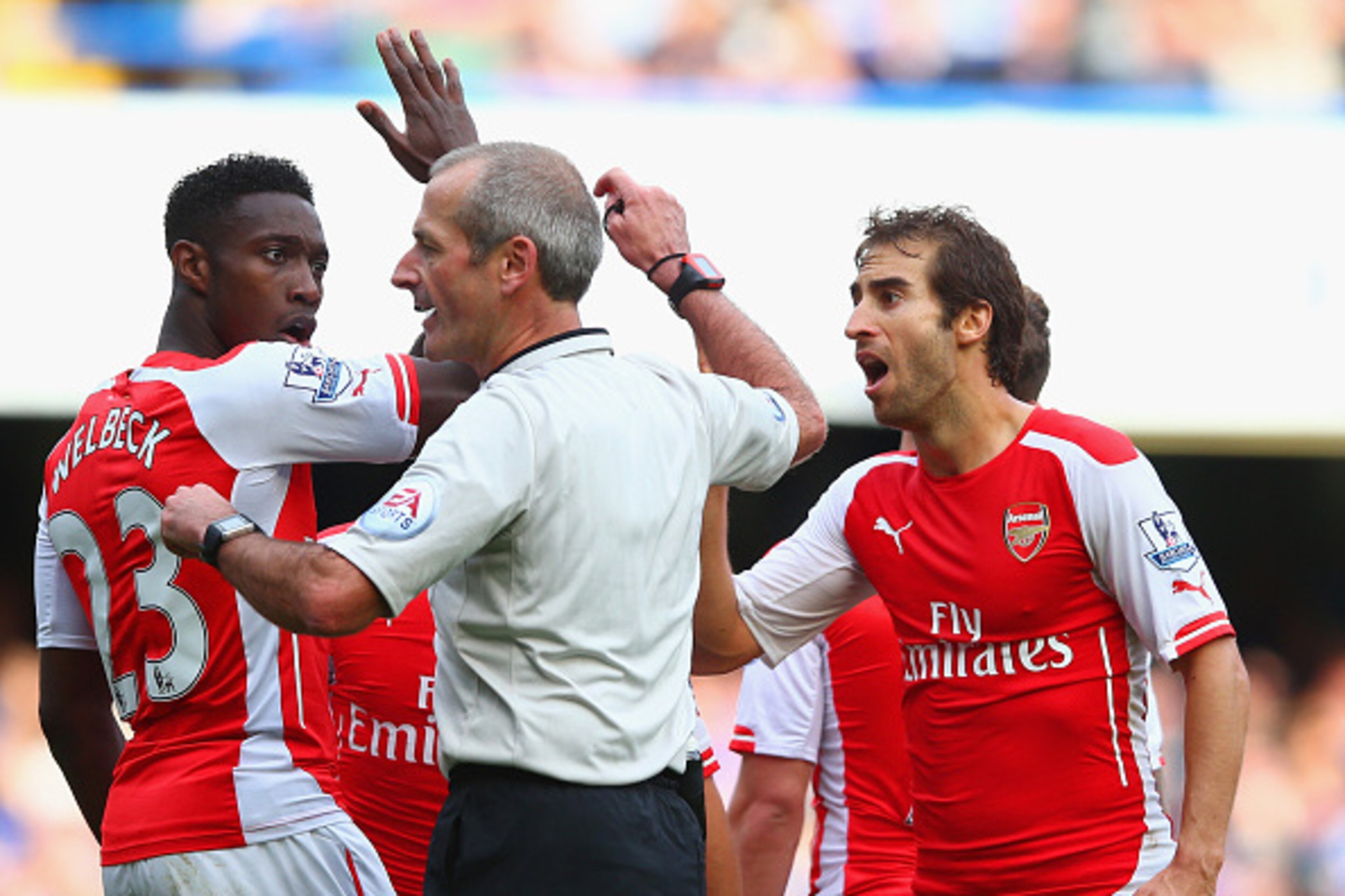 LONDON, ENGLAND - OCTOBER 05:  Danny Welbeck  and Mathieu Flamini of Arsenal surround Referee Martin Atkinson during the Barclays Premier League match between Chelsea and Arsenal at Stamford Bridge on October 4, 2014 in London, England.  (Photo by Paul Gi