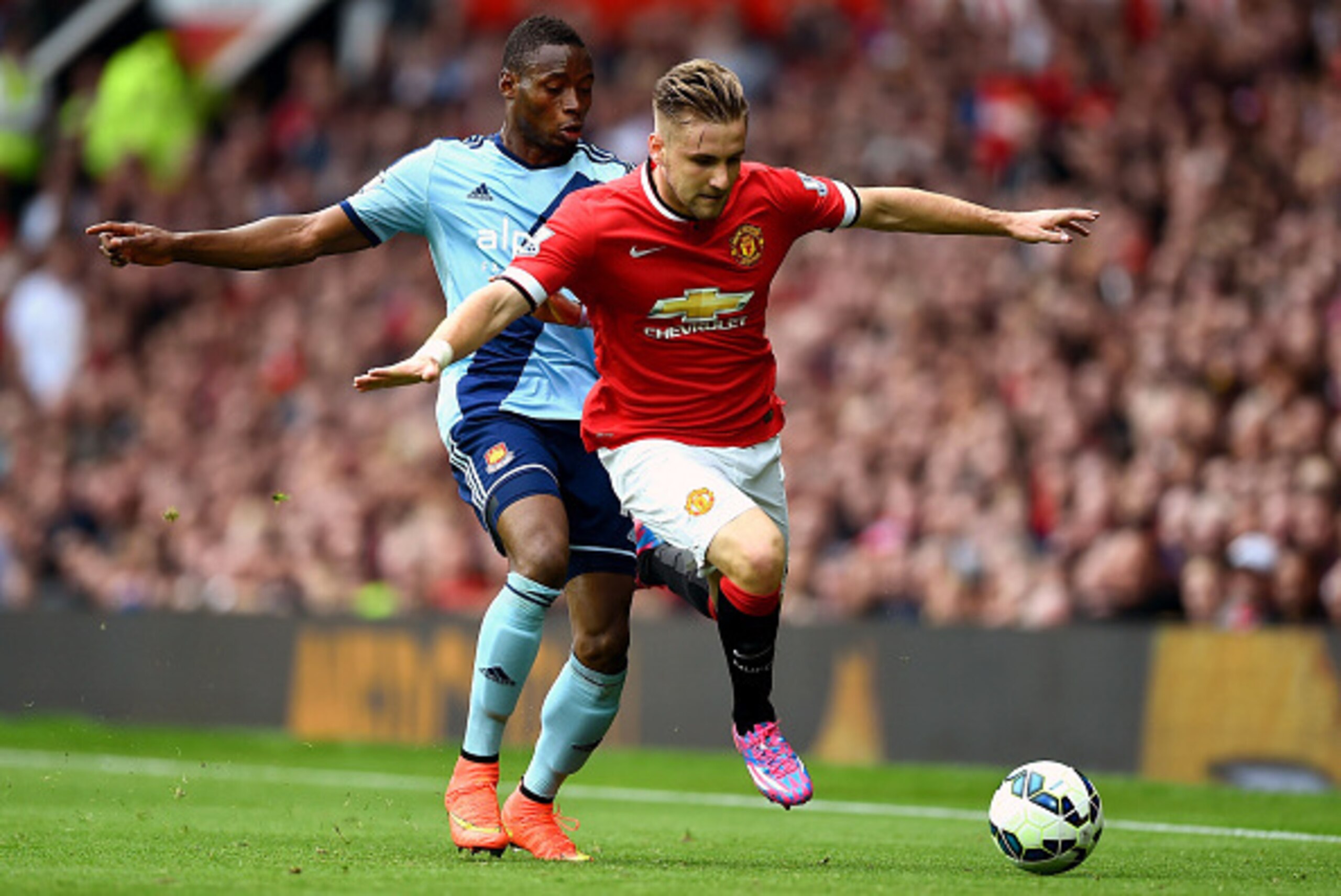 MANCHESTER, ENGLAND - SEPTEMBER 27:  Luke Shaw of Manchester United goes past the challenge from Diafra Sakho of West Ham during the Barclays Premier League match between Manchester United and West Ham United at Old Trafford on September 27, 2014 in Manch