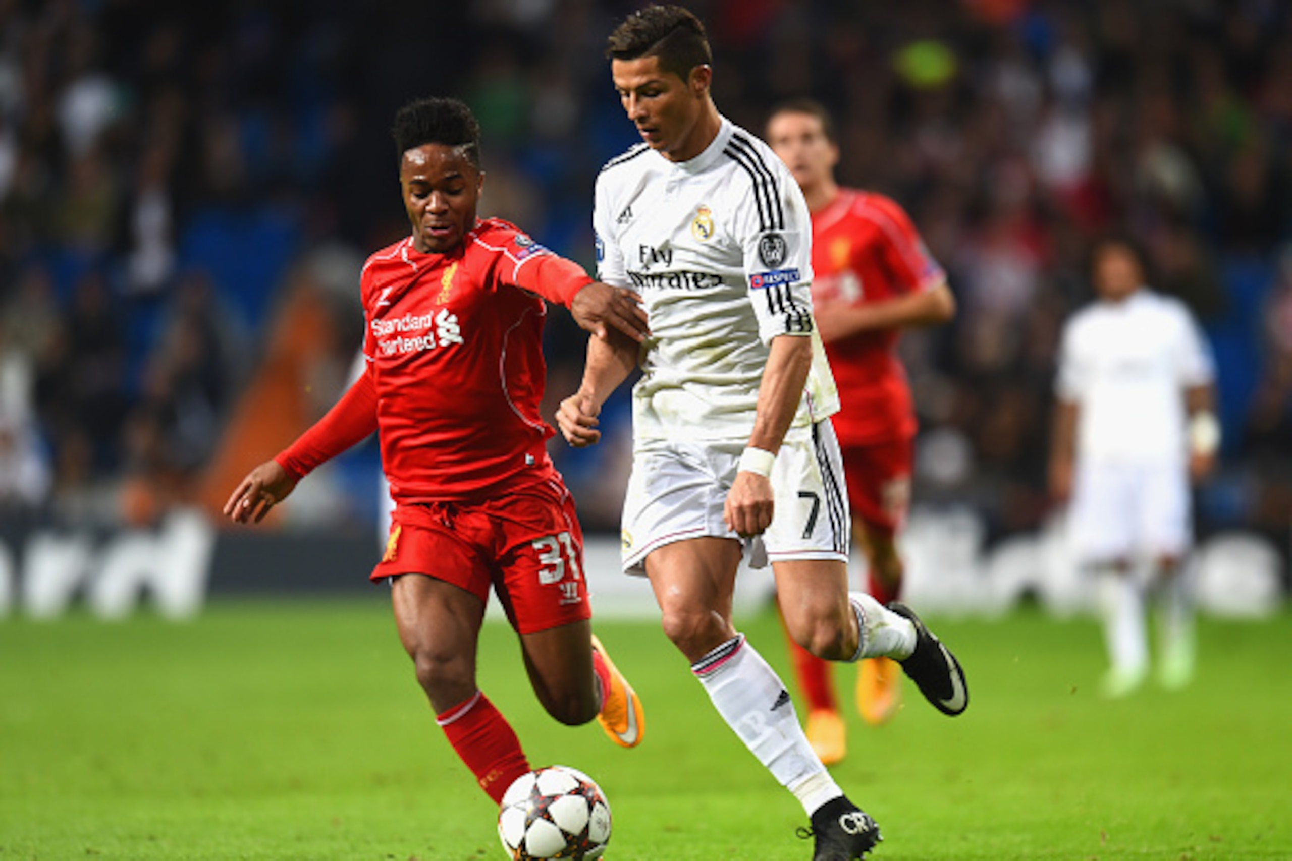 MADRID, SPAIN - NOVEMBER 04:  Raheem Sterling of Liverpool and Cristiano Ronaldo of Real Madrid CF battle for the ball during the UEFA Champions League Group B match between Real Madrid CF and Liverpool FC at Estadio Santiago Bernabeu on November 4, 2014 