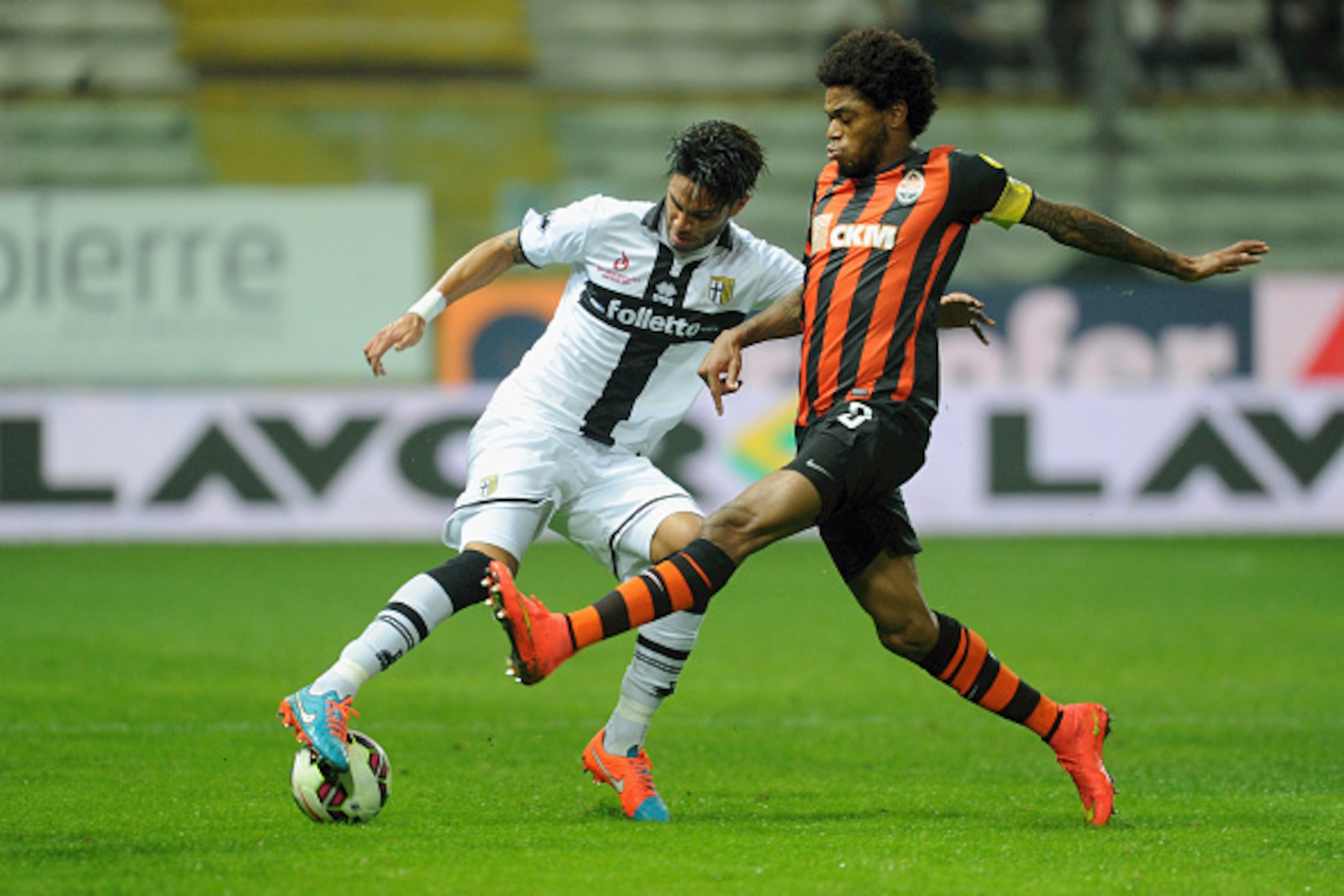 PARMA, ITALY - OCTOBER 09:  (L-R) Pedro Mendes of Parma FC competes for the with Adriano Luiz of FC Shakhtar Donetsk during the friendly match between Parma FC and FC Shakhtar Donetsk at Stadio Ennio Tardini on October 9, 2014 in Parma, Italy.  (Photo by 