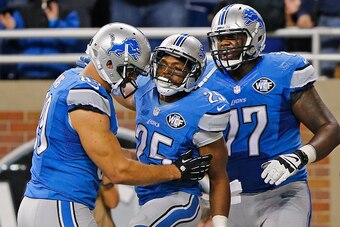 DETROIT, MI - NOVEMBER 09: Theo Riddick #25 of the Detroit Lions celebrates after scoring the game winning touchdown with teammates Kellen Davis #89 and Cornelius Lucas #77 of the Detroit Lions at Ford Field on November 09 , 2014 in Detroit, Michigan. The