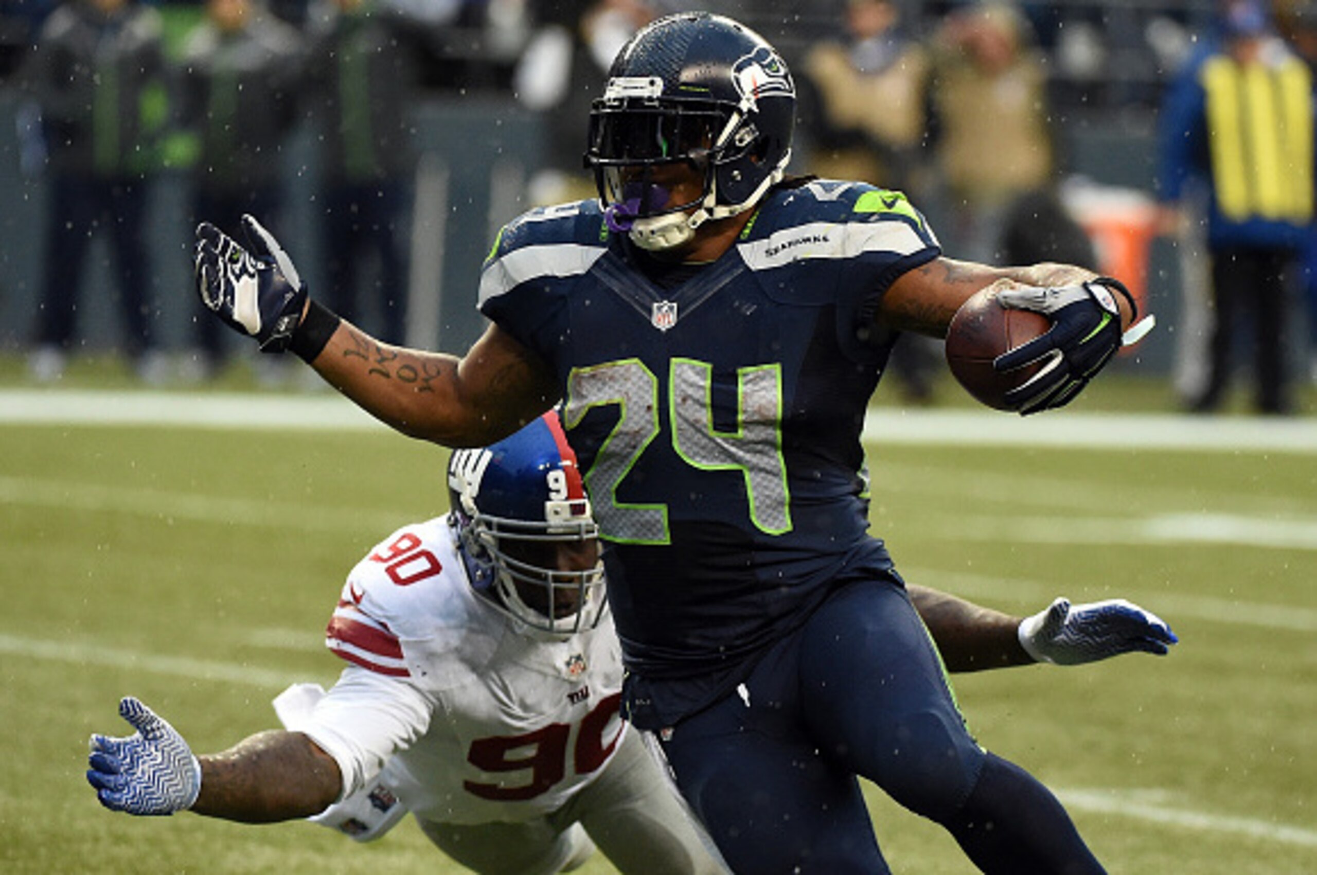 SEATTLE, WA - NOVEMBER 09: Running back Marshawn Lynch #24 of the Seattle Seahawks avoids the tackle of defensive end Jason Pierre-Paul #90 of the New York Giants during the third quarter of the game against the New York Giants at CenturyLink Field on Nov