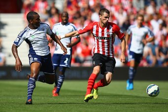 SOUTHAMPTON, ENGLAND - AUGUST 23: Morgan Schneiderlin of Southampton holds off a challenge from Andre Wisdom of West Brom during the Barclays Premier League match between Southampton and West Bromwich Albion at St Mary's Stadium on August 23, 2014 in Sout