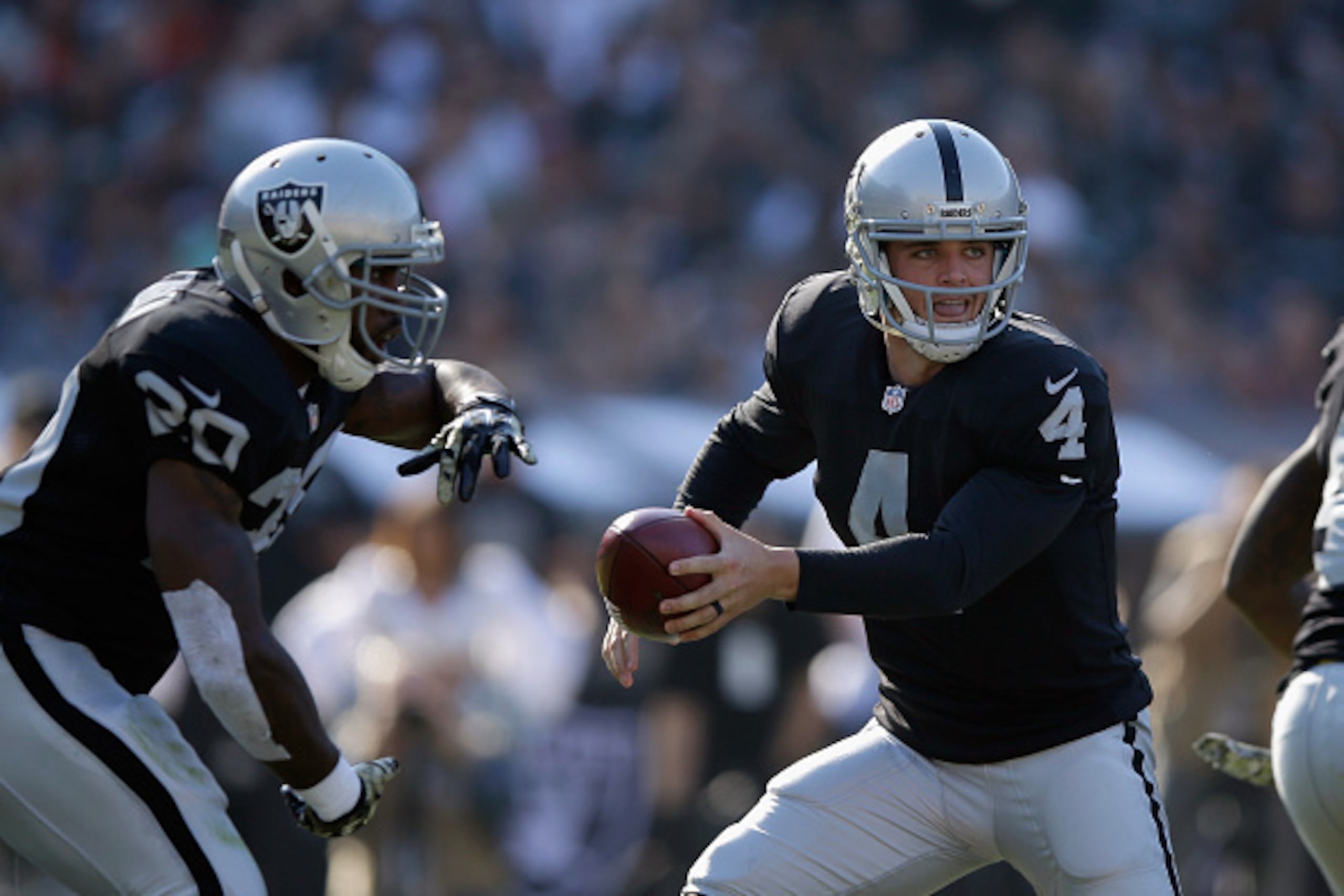 OAKLAND, CA - NOVEMBER 09:  Derek Carr #4 of the Oakland Raiders hands off to Darren McFadden #20 of the Oakland Raiders against the Denver Broncos at O.co Coliseum on November 9, 2014 in Oakland, California.  (Photo by Ezra Shaw/Getty Images)