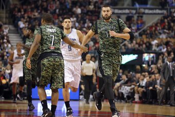 Nov 11, 2014; Toronto, Ontario, CAN; Toronto Raptors center Jonas Valanciunas (17) is congratulated by point guard Kyle Lowry (7) after scoring a basket against the Orlando Magic at Air Canada Centre. The Raptors beat the Magic 104-100. Mandatory Credit: