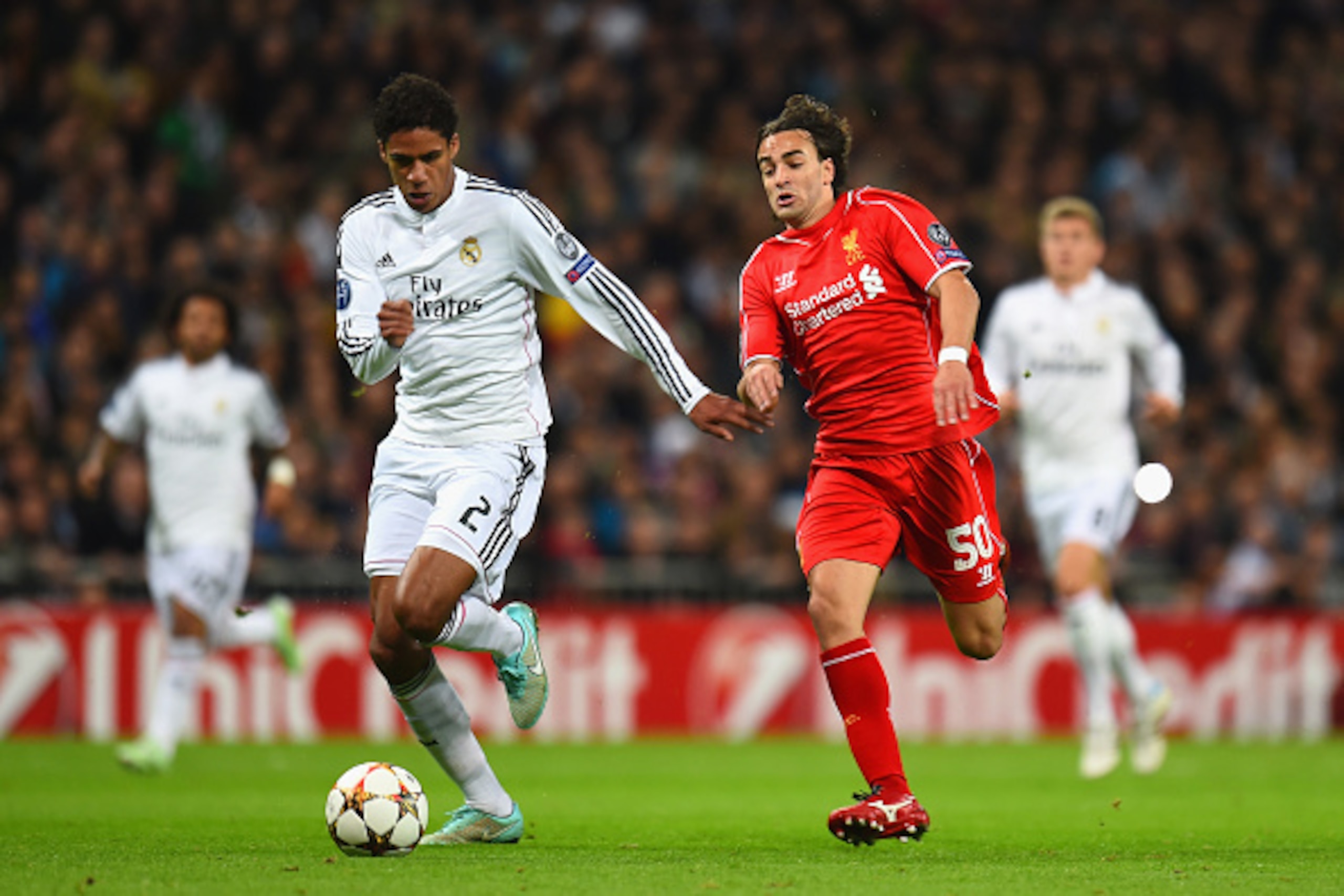 MADRID, SPAIN - NOVEMBER 04:  Raphael Varane of Real Madrid CF and Lazar Markovic of Liverpool compete for the ball during the UEFA Champions League Group B match between Real Madrid CF and Liverpool FC at Estadio Santiago Bernabeu on November 4, 2014 in 