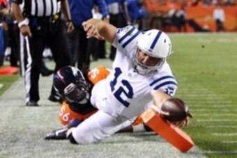 Sep 7, 2014; Denver, CO, USA; Indianapolis Colts quarterback Andrew Luck (12) reaches the ball over the goal line for a touchdown during the first half against the against the Denver Broncos at Sports Authority Field at Mile High. Mandatory Credit: Chris 