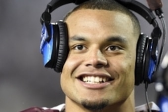 Nov 8, 2014; Starkville, MS, USA; Mississippi State Bulldogs quarterback Dak Prescott (15) smiles while on the headsets after coming out of the game against the UT Martin Skyhawks during the fourth quarter at Davis Wade Stadium. Mandatory Credit: John Dav