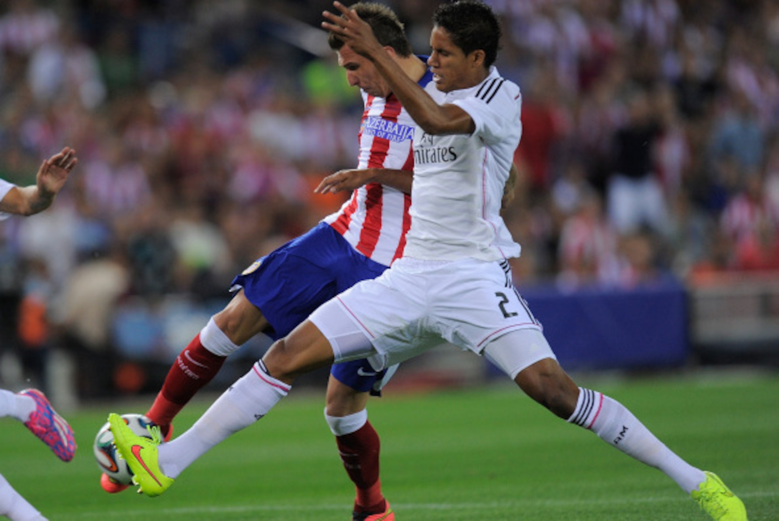 MADRID, SPAIN - AUGUST 22:  Mario Mandzukic of Club Atletico de Madrid beats Raphael Varane of Real Madrid to score his team's opening goal during the Supercopa, second leg match between Club Atletico de Madrid and Real Madrid at Vicente Caldron stadium o