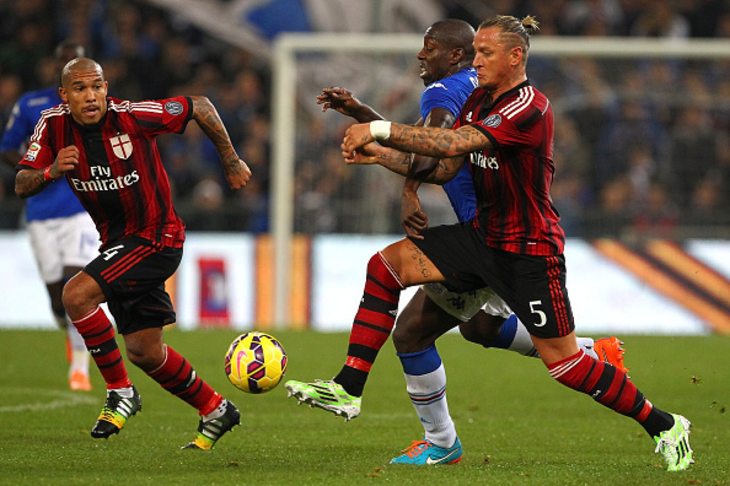 GENOA, ITALY - NOVEMBER 08:  Stefano Chuka Okaka (C) of UC Sampdoria is challenged by Philippe Mexes (R) and Nigel De Jong (L) of AC Milan during the Serie A match between UC Sampdoria and AC Milan at Stadio Luigi Ferraris on November 8, 2014 in Genoa, It