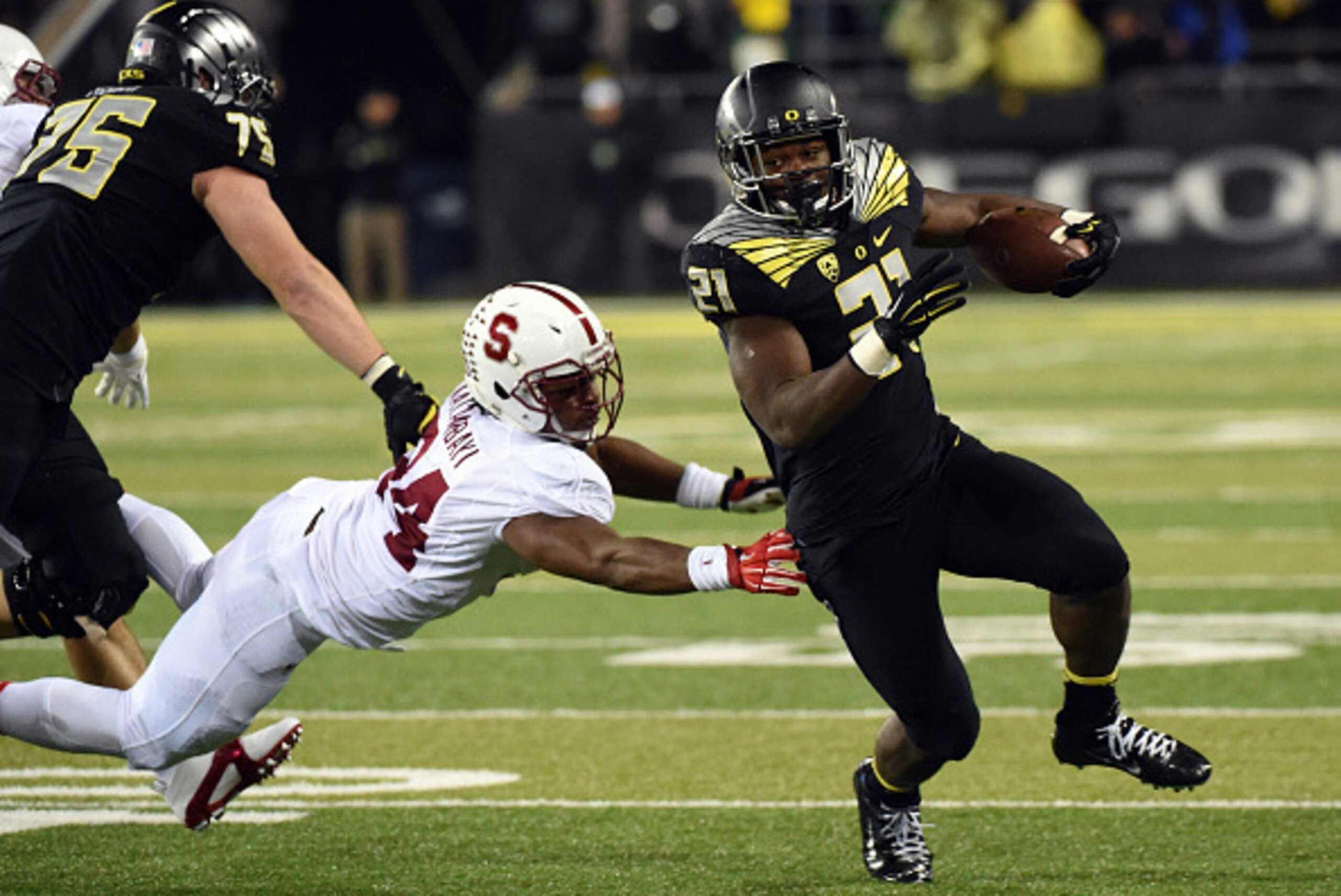 EUGENE, OR - NOVEMBER 1: Running back Royce Freeman #21 of the Oregon Ducks avoids the tackle of linebacker Peter Kalambayi #34 of the Stanford Cardinal during the fourth quarter of the game at Autzen Stadium on November 1, 2014 in Eugene, Oregon. The Duc