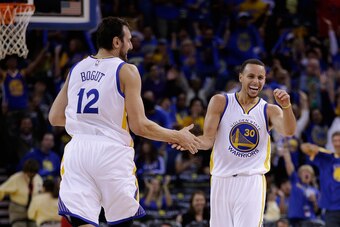 OAKLAND, CA - NOVEMBER 01:  Stephen Curry #30 of the Golden State Warriors reacts with Andrew Bogut #12 after he threw a long down court assist to Klay Thompson #11 who made a three-point basket against the Los Angeles Lakers at ORACLE Arena on November 1