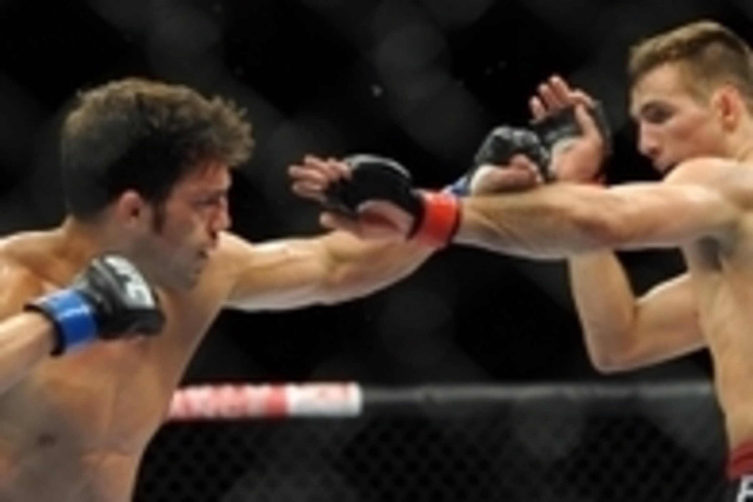 Jul 27, 2013; Seattle, WA, USA;  Rory MacDonald (red tape) blocks a punch thrown by Jake Ellenberger (blue tape) during their welterweight bout at Key Arena. McDonald won by a decision. Mandatory Credit: Jayne Kamin-Oncea-USA TODAY Sports