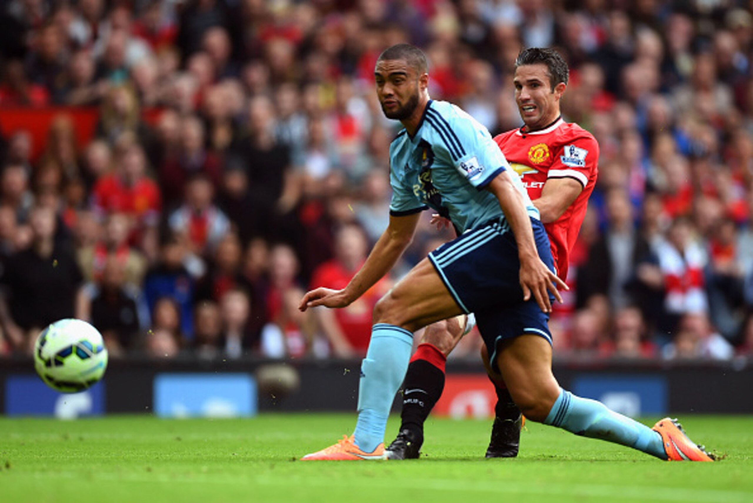 MANCHESTER, ENGLAND - SEPTEMBER 27: Robin van Persie of Manchester United shoots past Winston Reid of West Ham to score his team's second goal during the Barclays Premier League match between Manchester United and West Ham United at Old Trafford on Sept MANCHESTER, ENGLAND - SEPTEMBER 27: Robin van Persie of Manchester United shoots past Winston Reid of West Ham to score his team's second goal during the Barclays Premier League match between Manchester United and West Ham United at Old Trafford on Sept