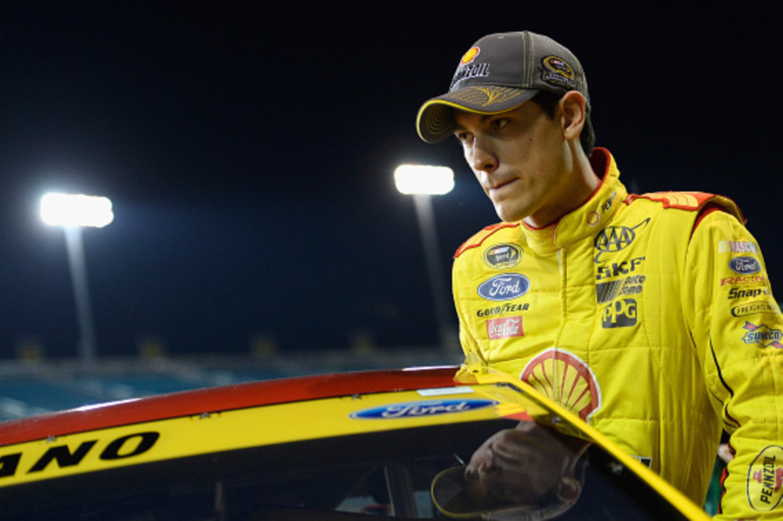 HOMESTEAD, FL - NOVEMBER 14:  Joey Logano, driver of the #22 Shell-Pennzoil Ford, climbs into his car on the grid during qualifying for the NASCAR Sprint Cup Series Ford EcoBoost 400 at Homestead-Miami Speedway on November 14, 2014 in Homestead, Florida. 