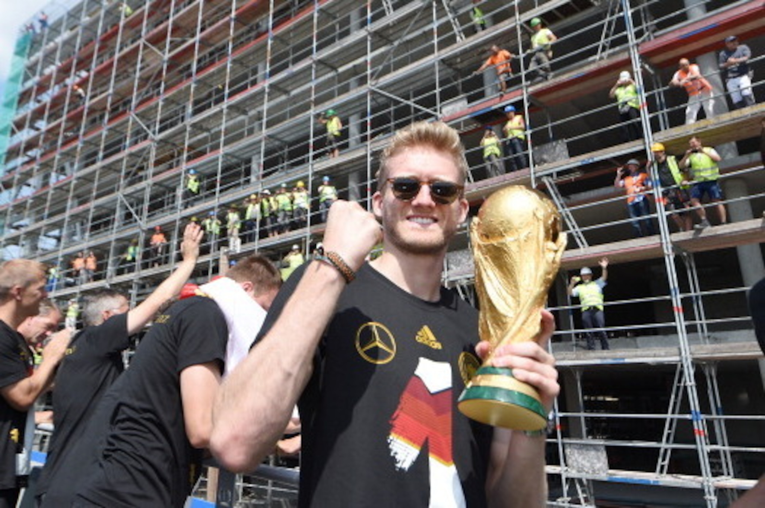 BERLIN, GERMANY - JULY 15: Andre Schuerrle celebrates on stage at the German team victory ceremony on July 15, 2014 in Berlin, Germany. Germany won the 2014 FIFA World Cup Brazil match against Argentina in Rio de Janeiro on July 13.  (Photo by Markus Gill