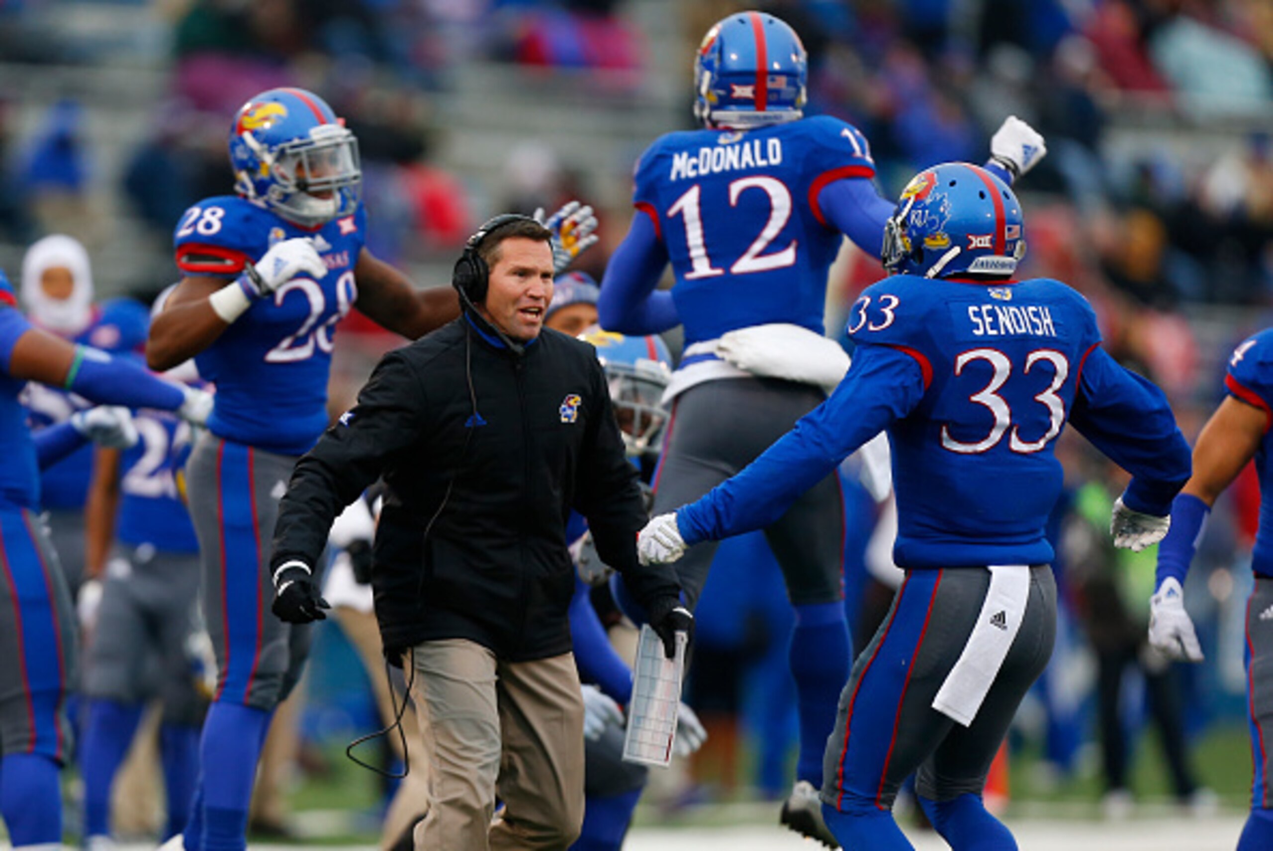 LAWRENCE, KS - NOVEMBER 15: Clint Bowen interim head coach of the Kansas Jayhawks celebrates with safety Cassius Sendish #33 after the TCU Horned Frogs were held on fourth in one in first quarter at Memorial Stadium on November 15, 2014 in Lawrence, Kansa