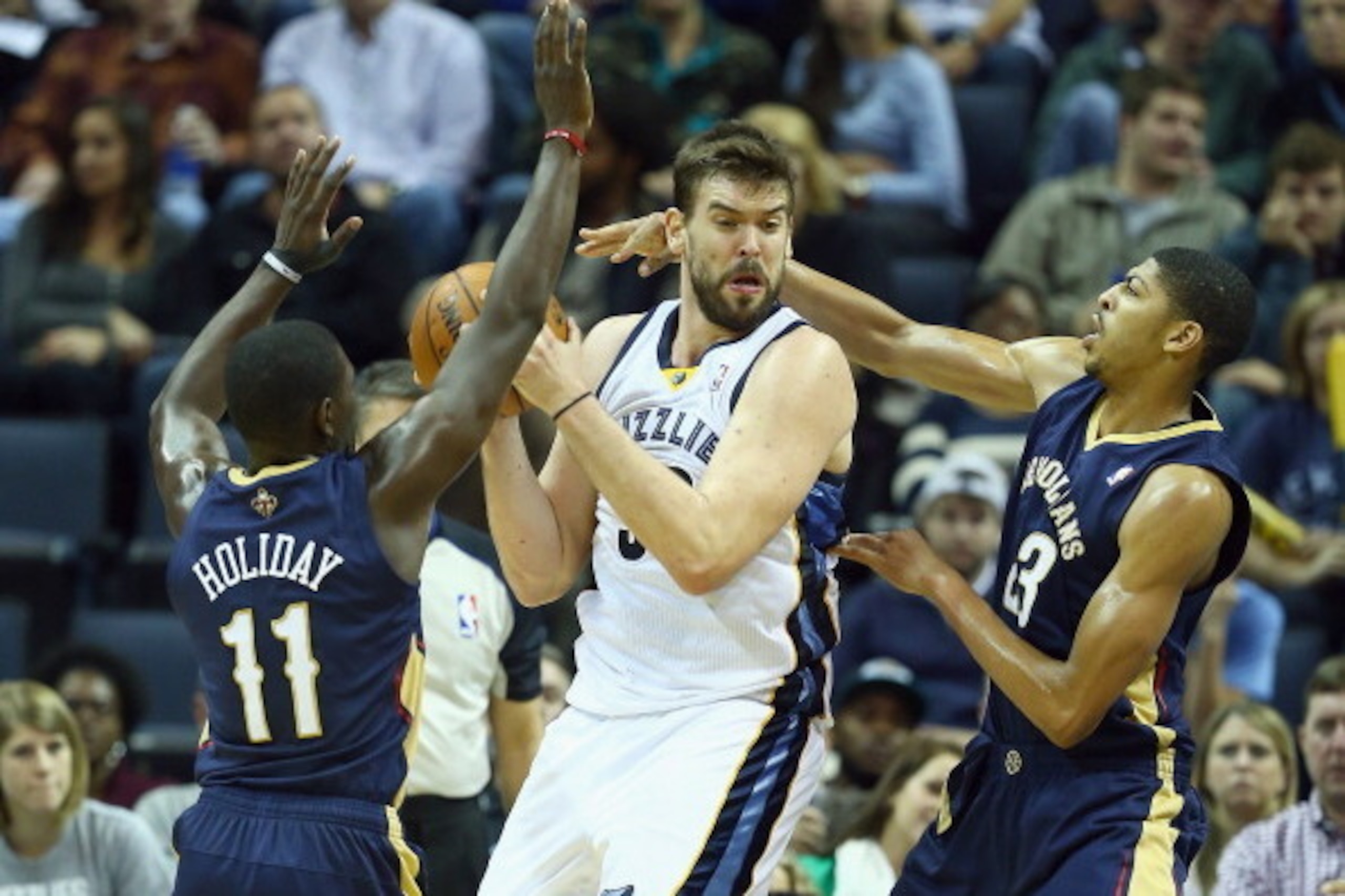 MEMPHIS, TN - NOVEMBER 06:  Marc Gasol #33 of the Memphis Grizzlies looks to pass the ball while defended by Jrue Holiday #11 and Anthony Davis #23 of the New Orleans Pelicans during the NBA game at FedExForum on November 6, 2013 in Memphis, Tennessee.  N