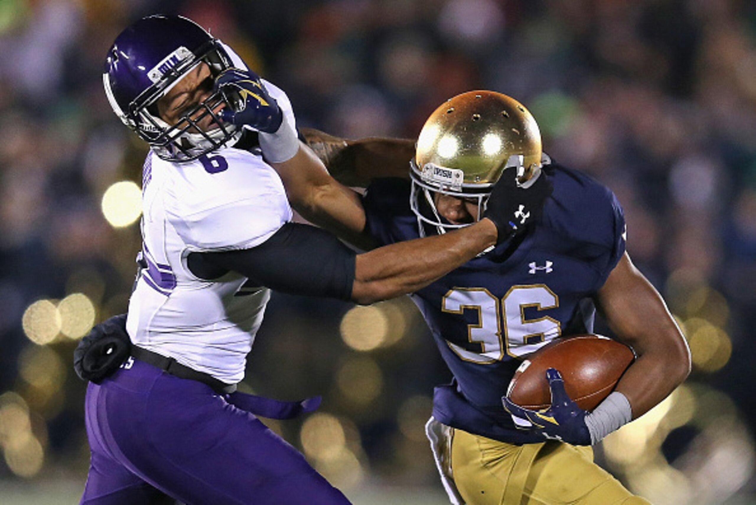 SOUTH BEND, IN - NOVEMBER 15: Cole Luke #36 of the Notre Dame Fighting Irish tries to fight off Tony Jones #6 of the Northwestern Wildcats after intercepting a pass at Notre Dame Stadium on November 15, 2014 in South Bend, Indiana. Northwestern defeated N