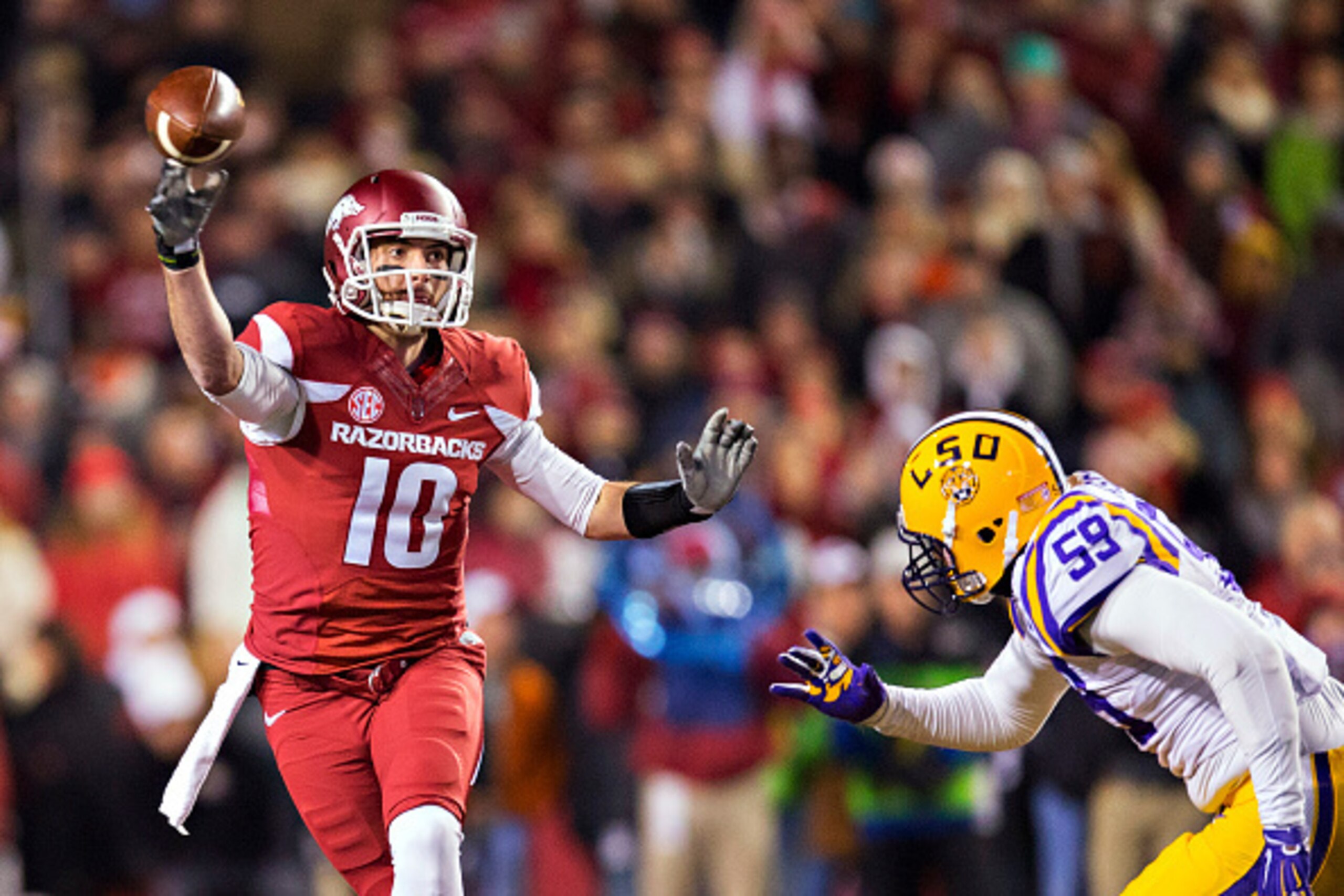 FAYETTEVILLE, AR - NOVEMBER 15:  Brandon Allen #10 of the Arkansas Razorbacks throws a pass under pressure in the first quarter from Jermauria Rasco #59 of the LSU Tigers at Razorback Stadium on November 15, 2014 in Fayetteville, Arkansas.  (Photo by Wesl