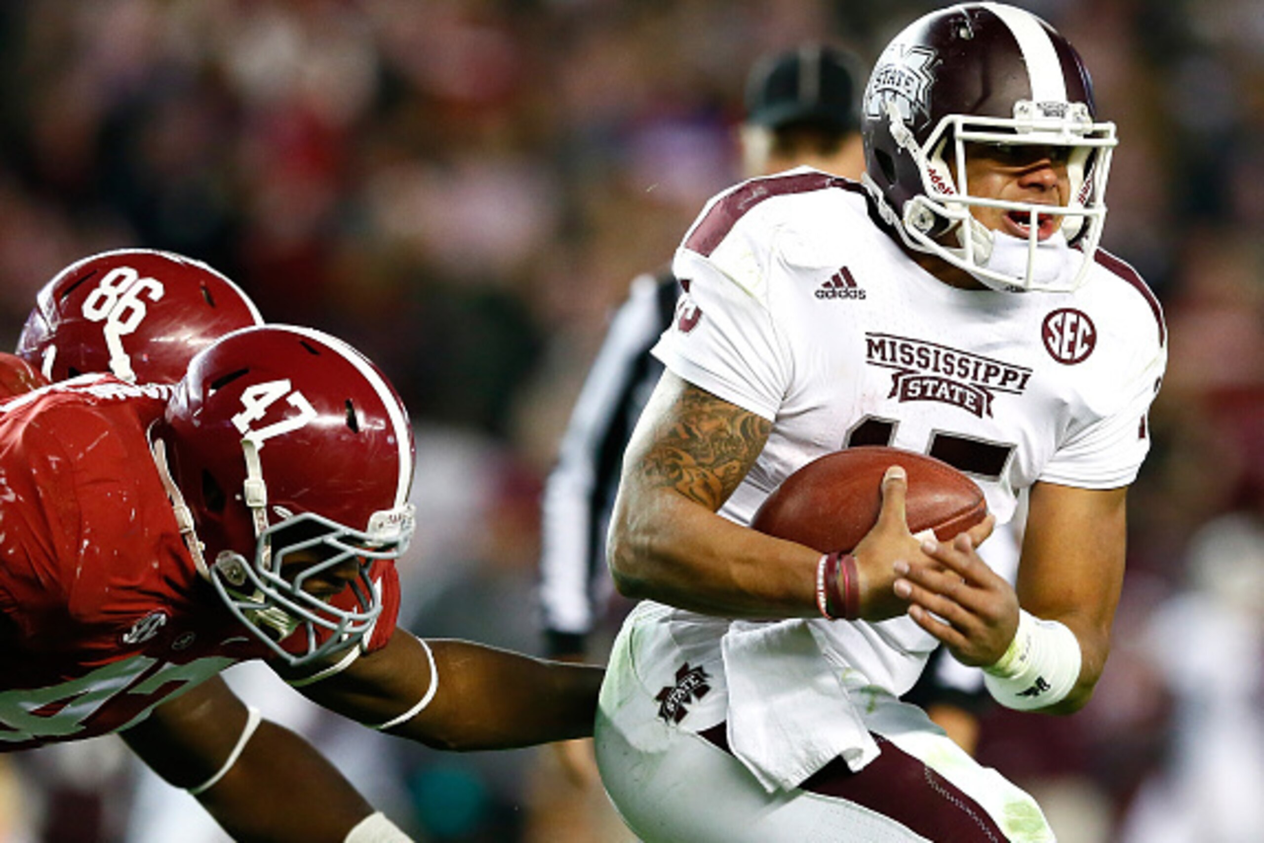 TUSCALOOSA, AL - NOVEMBER 15:  Dak Prescott #15 of the Mississippi State Bulldogs rushes away from A'Shawn Robinson #86 and Xzavier Dickson #47 of the Alabama Crimson Tide at Bryant-Denny Stadium on November 15, 2014 in Tuscaloosa, Alabama.  (Photo by Kev