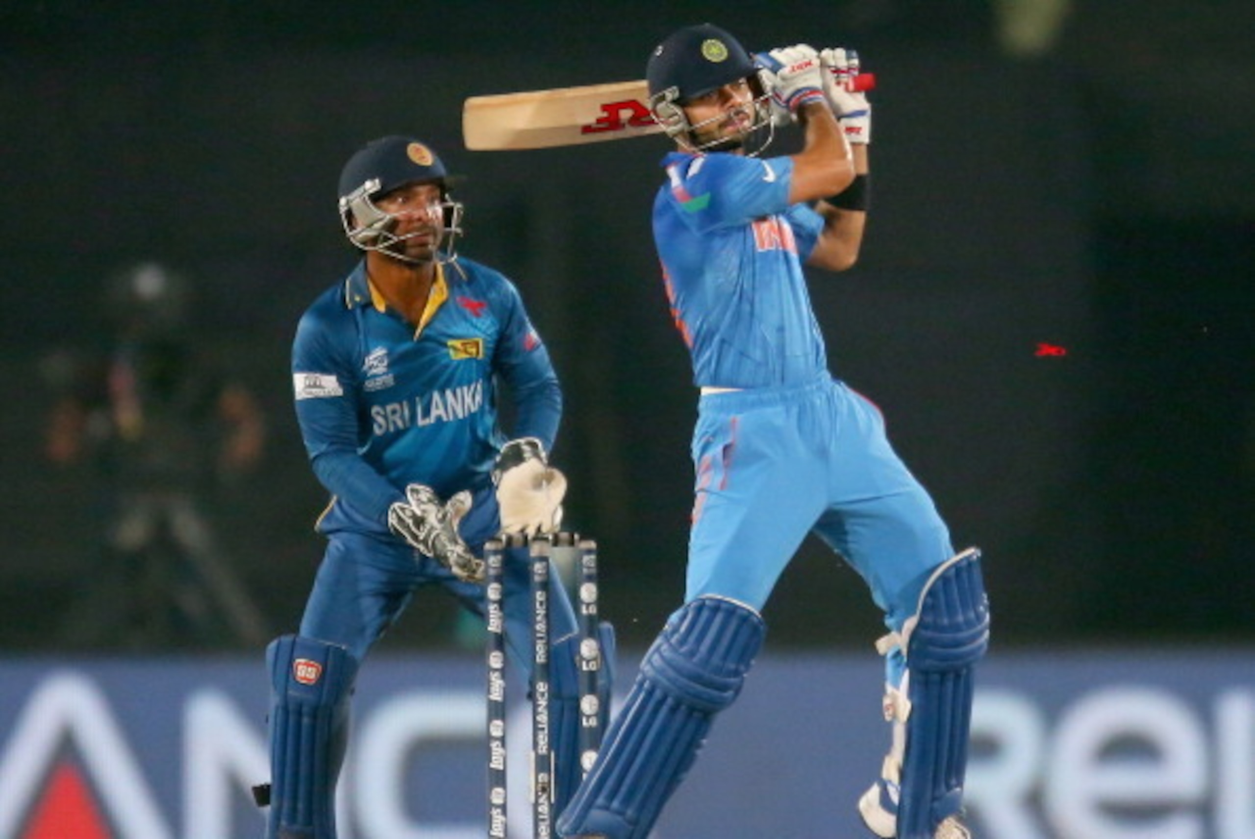 DHAKA, BANGLADESH - APRIL 06:  Virat Kohli of India bats as Kumar Sangakkara of Sri Lanka looks on during the Final of the ICC World Twenty20 Bangladesh 2014 between India and Sri Lanka at Sher-e-Bangla Mirpur Stadium on April 4, 2014 in Dhaka, Bangladesh