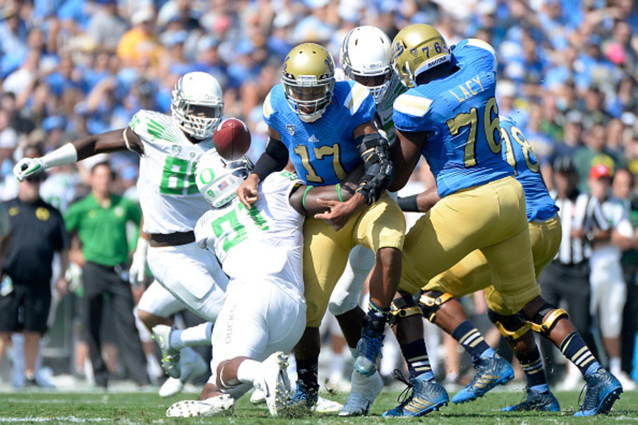PASADENA, CA - OCTOBER 11:  Brett Hundley #17 of the UCLA Bruins fumbles as he is sacked by Tony Washington #91 of the Oregon Ducks during the first quarter at Rose Bowl on October 11, 2014 in Pasadena, California.  (Photo by Harry How/Getty Images)