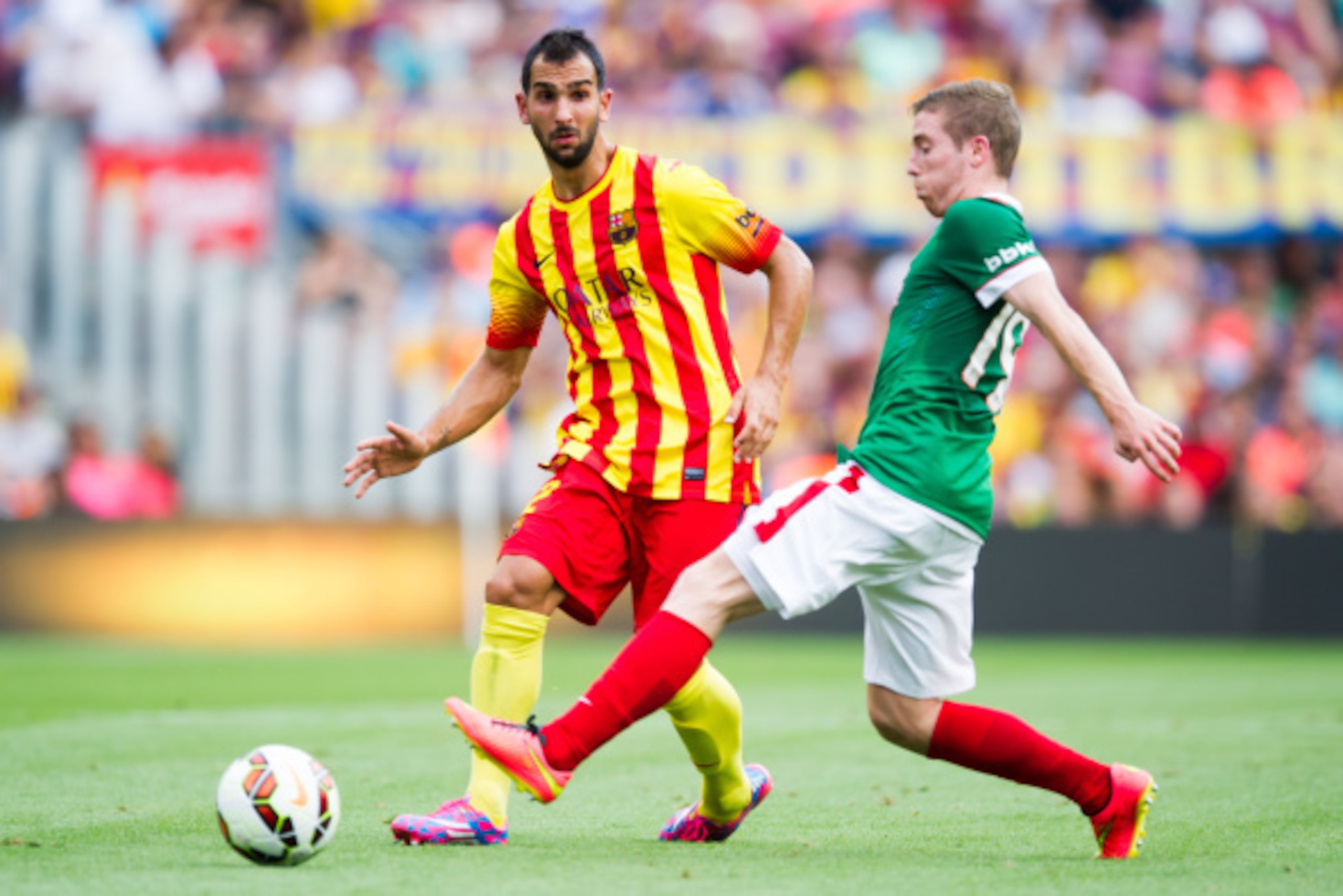 BARCELONA, SPAIN - SEPTEMBER 13: Martin Montoya (L) of FC Barcelona and Iker Muniain of Athletic Club compete for the ball during the La Liga match between FC Barcelona and Athletic Club at Camp Nou on September 13, 2014 in Barcelona, Spain. (Photo by Ale