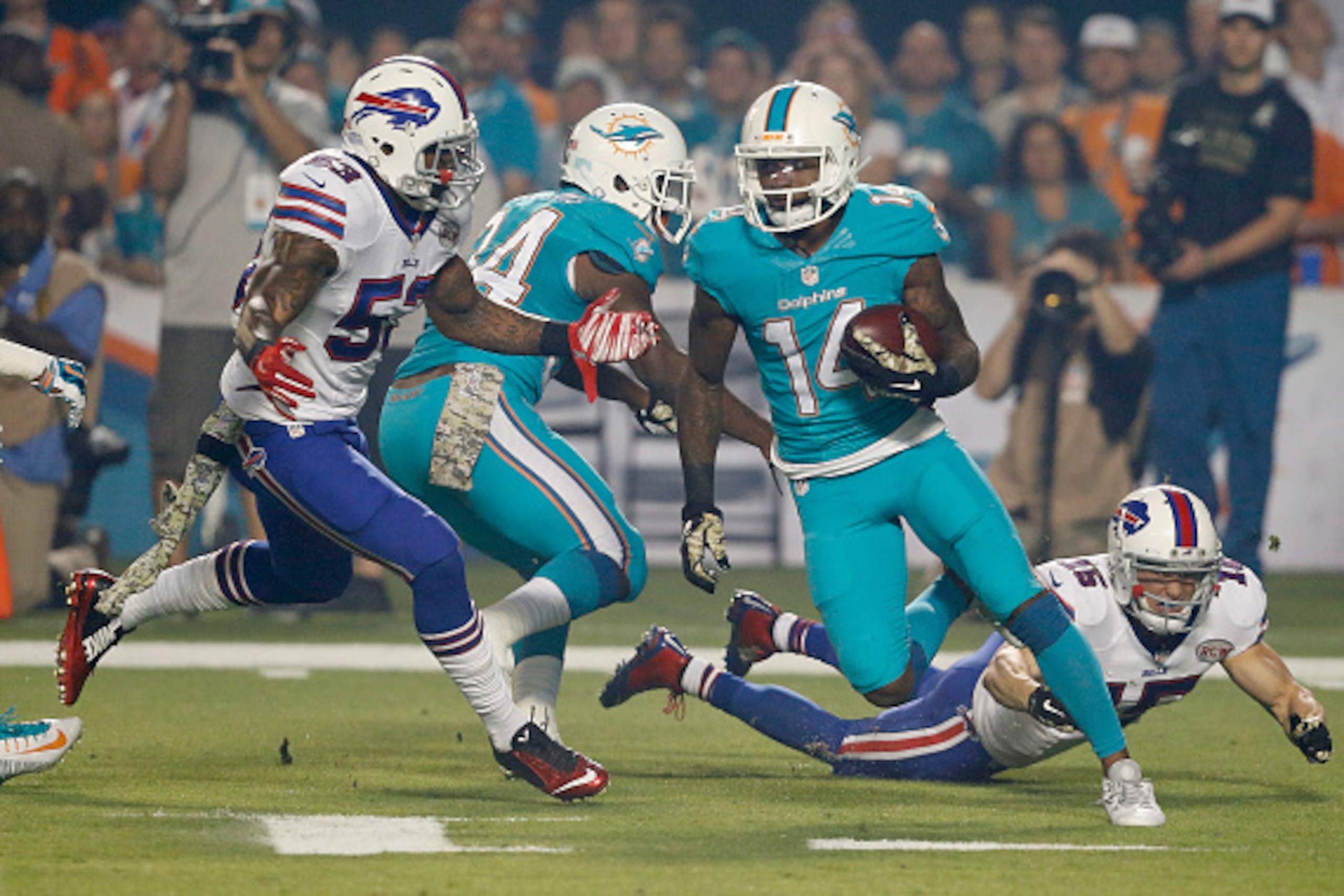 MIAMI GARDENS, FL - NOVEMBER 13:  Wide receiver Jarvis Landry #14 of the Miami Dolphins is pursued by outside linebacker Nigel Bradham #53 of the Buffalo Bills in the first quarter of a game at Sun Life Stadium on November 13, 2014 in Miami Gardens, Flori