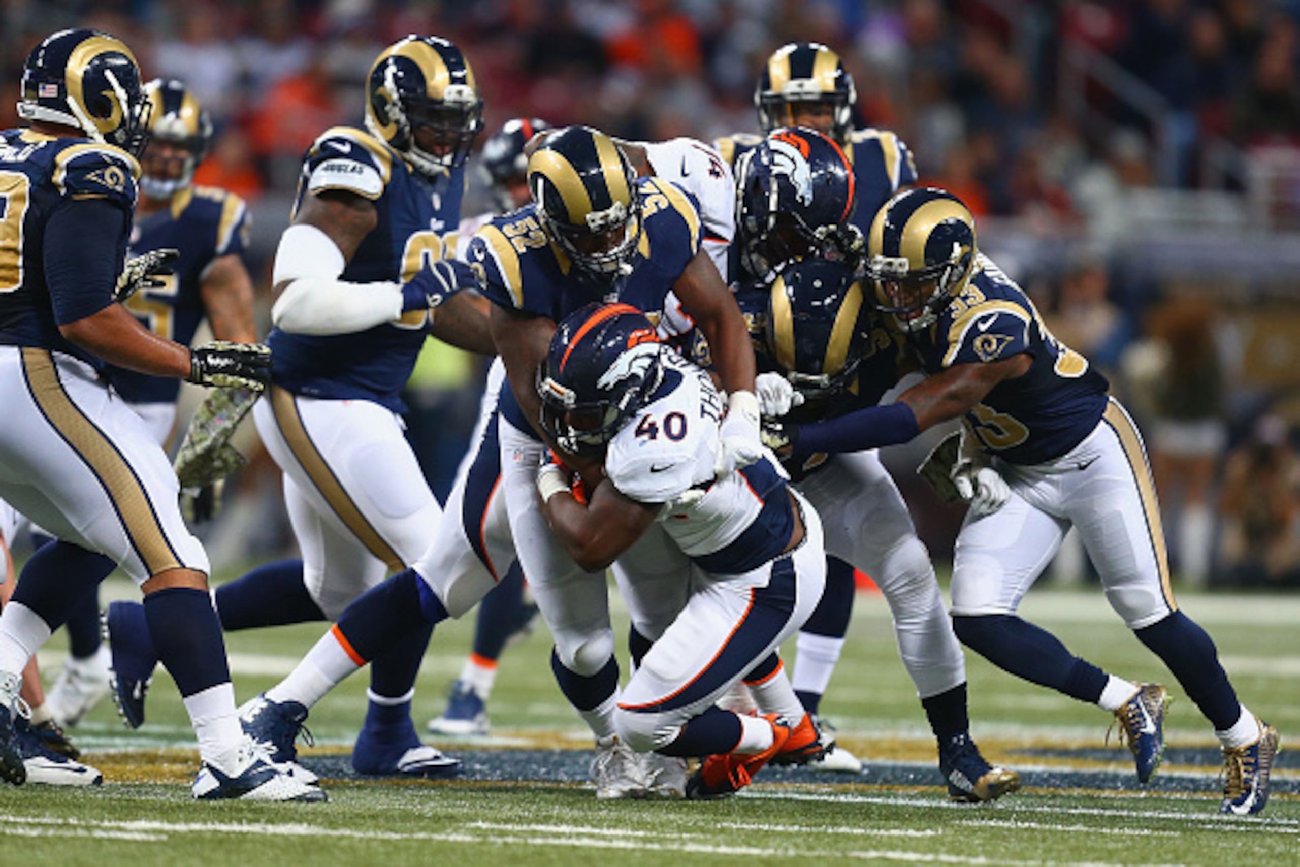 ST. LOUIS, MO - NOVEMBER 16: Juwan Thompson #40 of the Denver Broncos is tackled by Alec Ogletree #52 of the St. Louis Rams and teammates in the fourth quarter at the Edward Jones Dome on November 16, 2014 in St. Louis, Missouri.  The Rams beat the Bronco