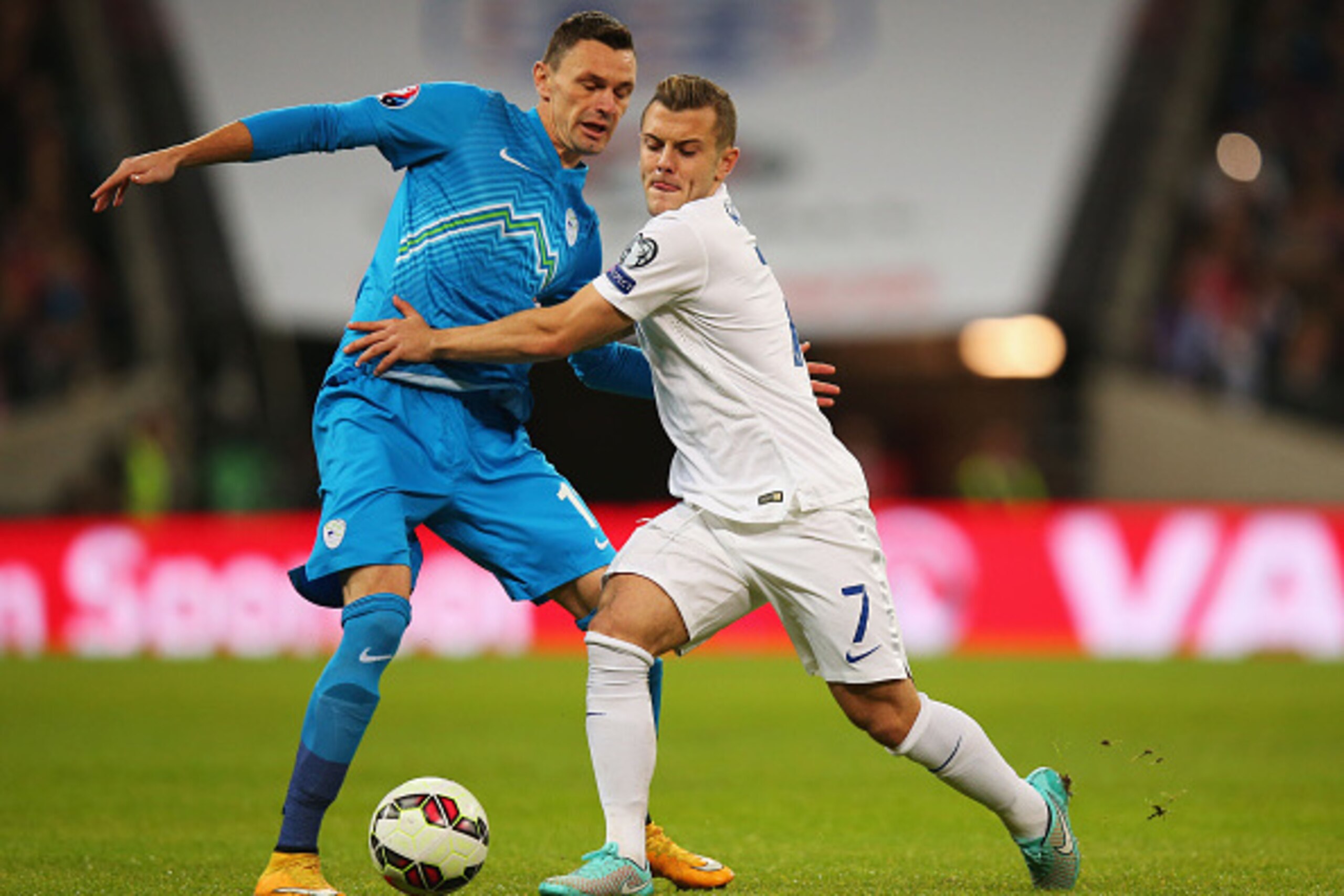 LONDON, ENGLAND - NOVEMBER 15:  Jack Wilshere of England battles with Milivoje Novakovic of Slovenia during the EURO 2016 Qualifier Group E match between England and Slovenia at Wembley Stadium on November 15, 2014 in London, England.  (Photo by Bryn Lenn