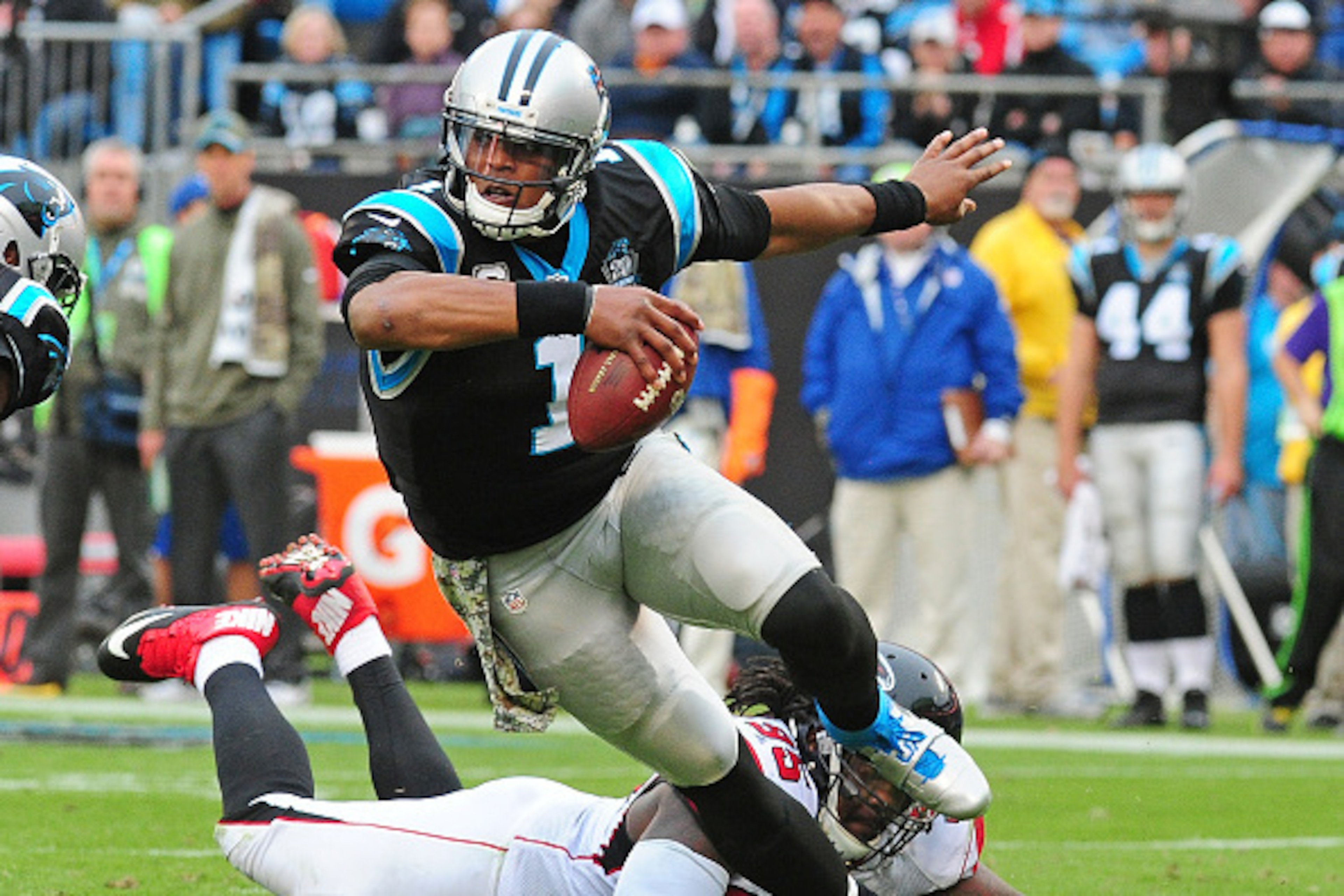CHARLOTTE, NC - NOVEMBER 16: Cam Newton #1 of the Carolina Panthers scrambles away from Jonathan Babineaux #95 of the Atlanta Falcons at Bank Of America Stadium on November 16, 2014 in Charlotte, North Carolina. (Photo by Scott Cunningham/Getty Images)