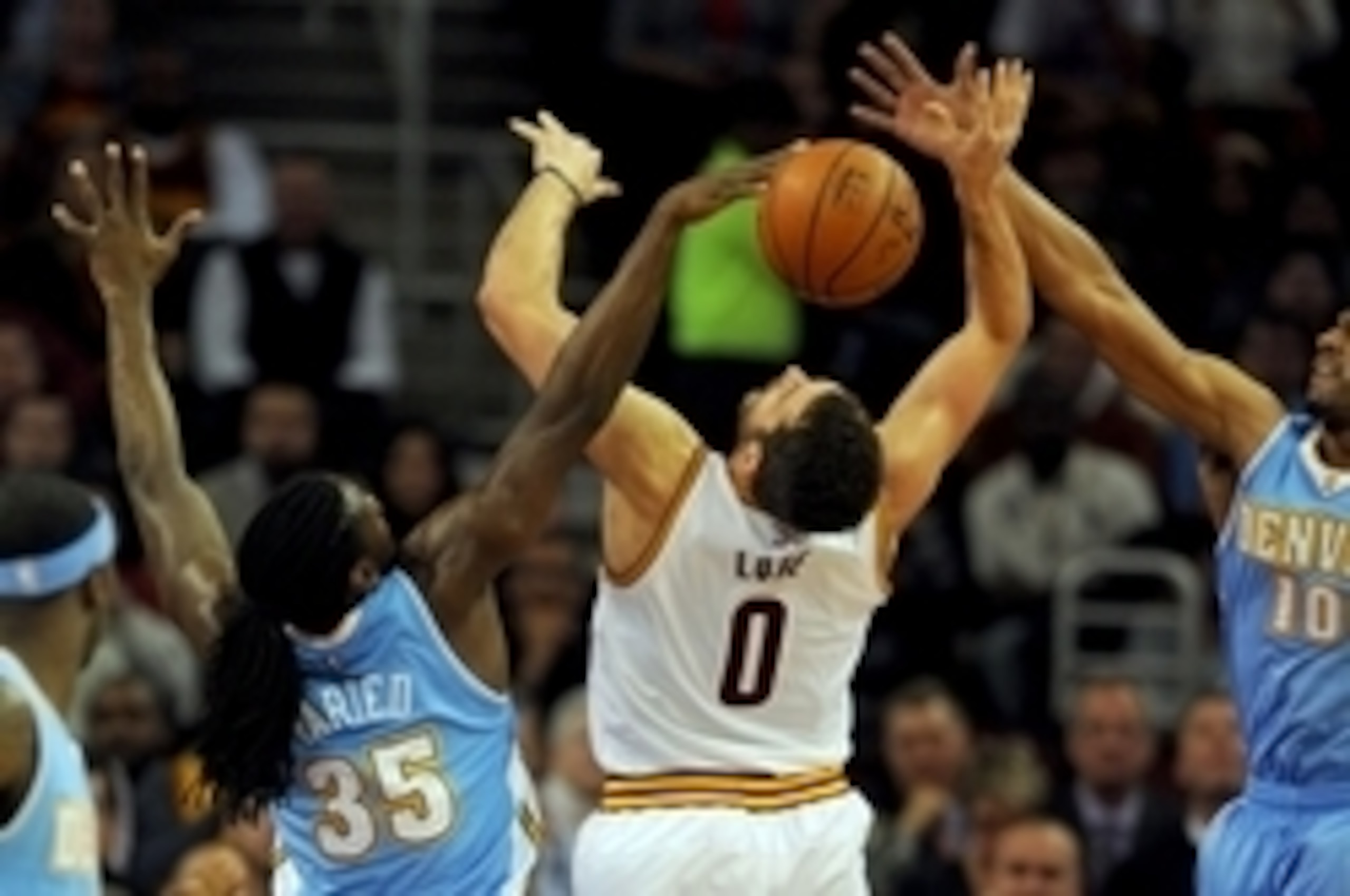Nov 17, 2014; Cleveland, OH, USA; Cleveland Cavaliers forward Kevin Love (0) is fouled by Denver Nuggets forward Kenneth Faried (35) and guard Arron Afflalo (10) during the first quarter at Quicken Loans Arena. Mandatory Credit: Ken Blaze-USA TODAY Sports