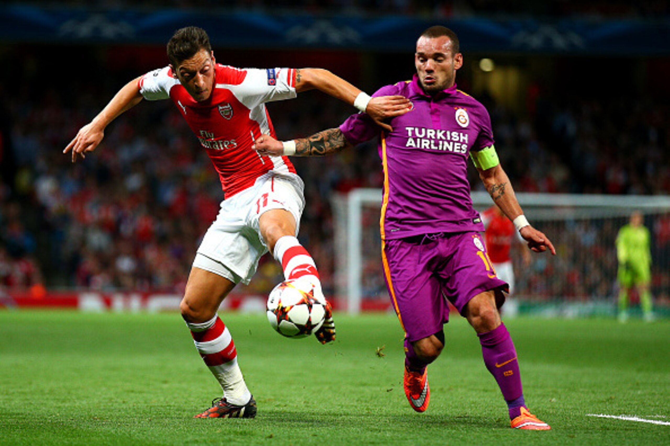 LONDON, ENGLAND - OCTOBER 01:  Mesut Oezil of Arsenal battles for tha ball with Wesley Sneijder of Galatasaray AS during the UEFA Champions League group D match between Arsenal FC and Galatasaray AS at Emirates Stadium on October 1, 2014 in London, United