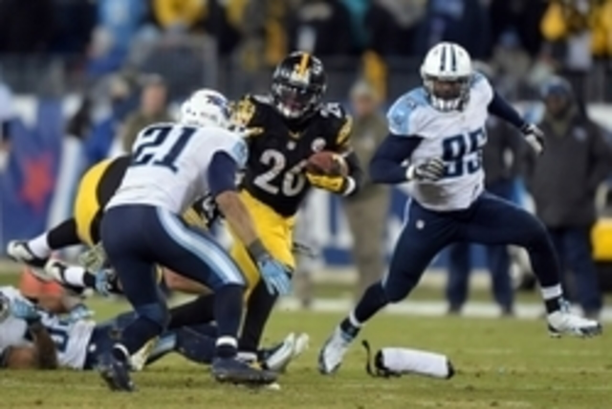 Nov 17, 2014; Nashville, TN, USA; Pittsburgh Steelers running back Le'Veon Bell (26) is defended by Tennessee Titans safety George Wilson (21) and linebacker Kamerion Wimbley (95) at LP Field. The Steelers defeated the Titans 27-24. Mandatory Credit: Kirb